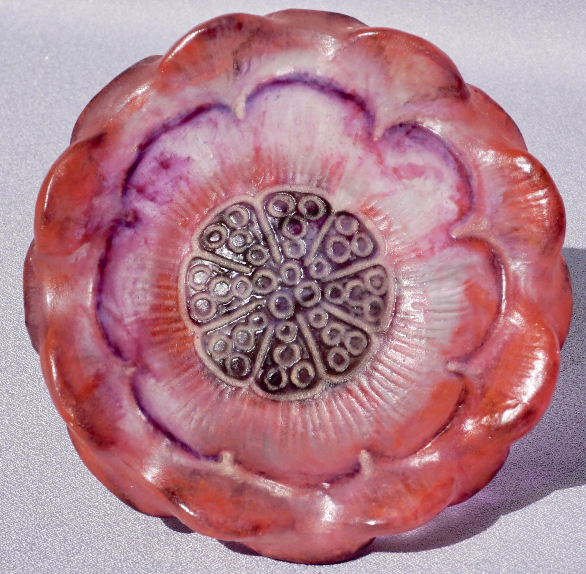 This Pâte de Verre footed small coupe by G. Argy-Rousseau is a molded open lotus floral blossom with red and purple highlights with brown center against a background of mottled clear and dark orange. Beautiful period example of Art Nouveau, Art Deco