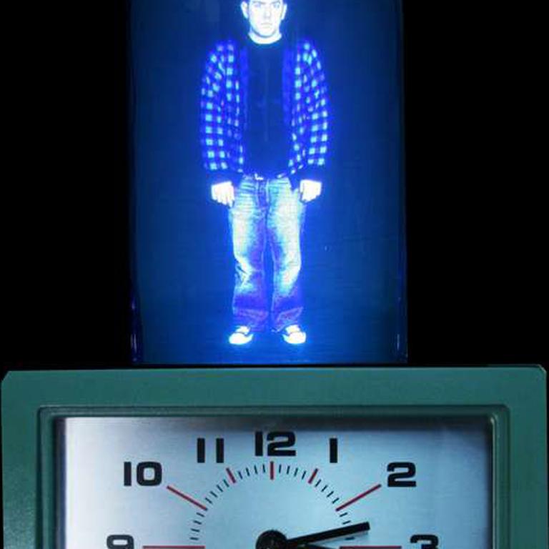 Item Description:
Mixed media interactive video sculpture
10 videos of 10 minute loops
11 x 24 x 11 inches, edition of 6 + AP
2011

A time card punch clock with a video person projected into a dome on top. As the viewer punches the time cards, the