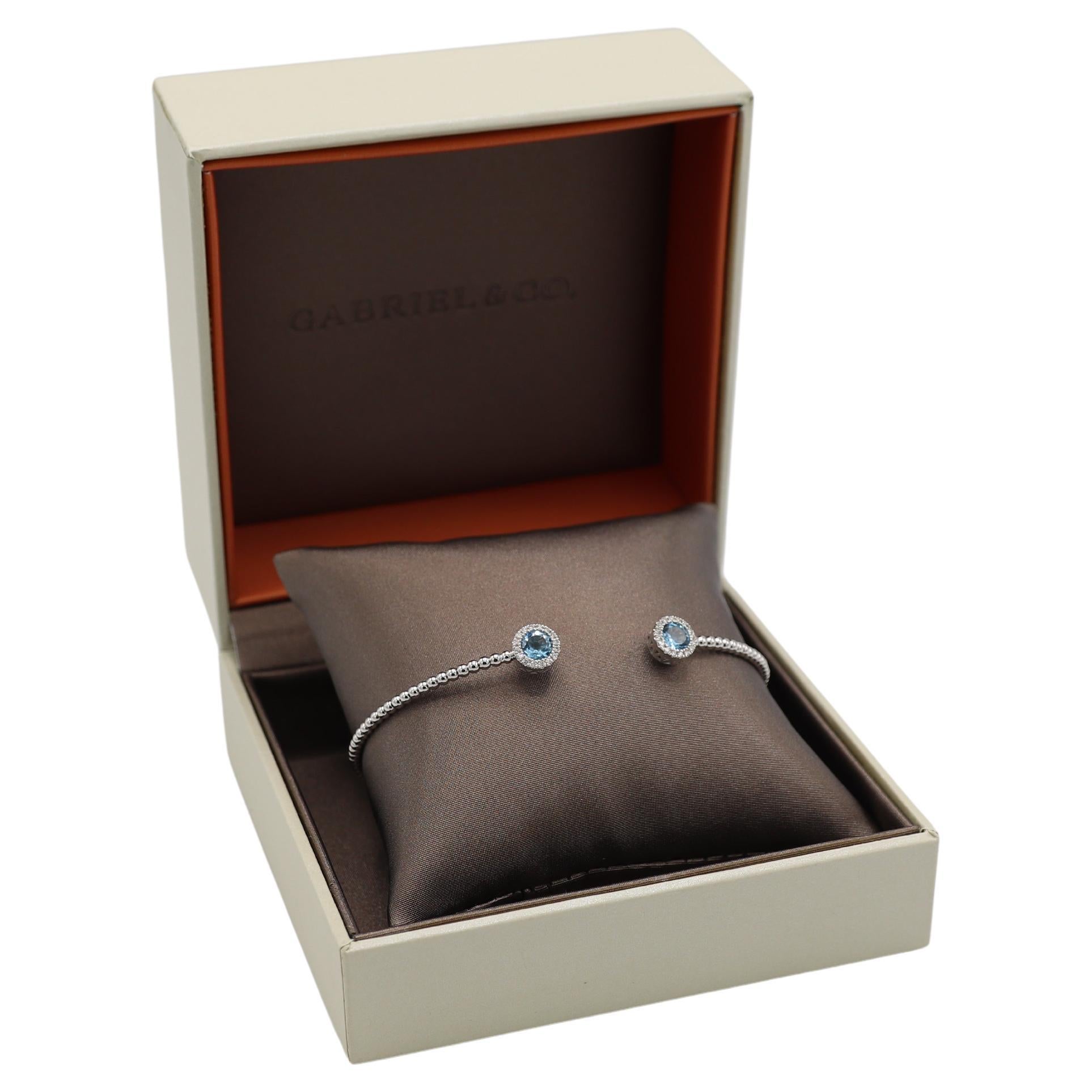 Gabriel & Co. Bracciale in oro bianco Bujukan con topazio blu e diamanti naturali
Metallo: oro bianco 14k
Peso: 6.04 grammi
Diamanti: 0,16 CTW G-H VS-SI
Dimensioni: Si adatta a un polso da 7,5 pollici
Diametro: 2,75 pollici
Larghezza: 2,2 - 7,7