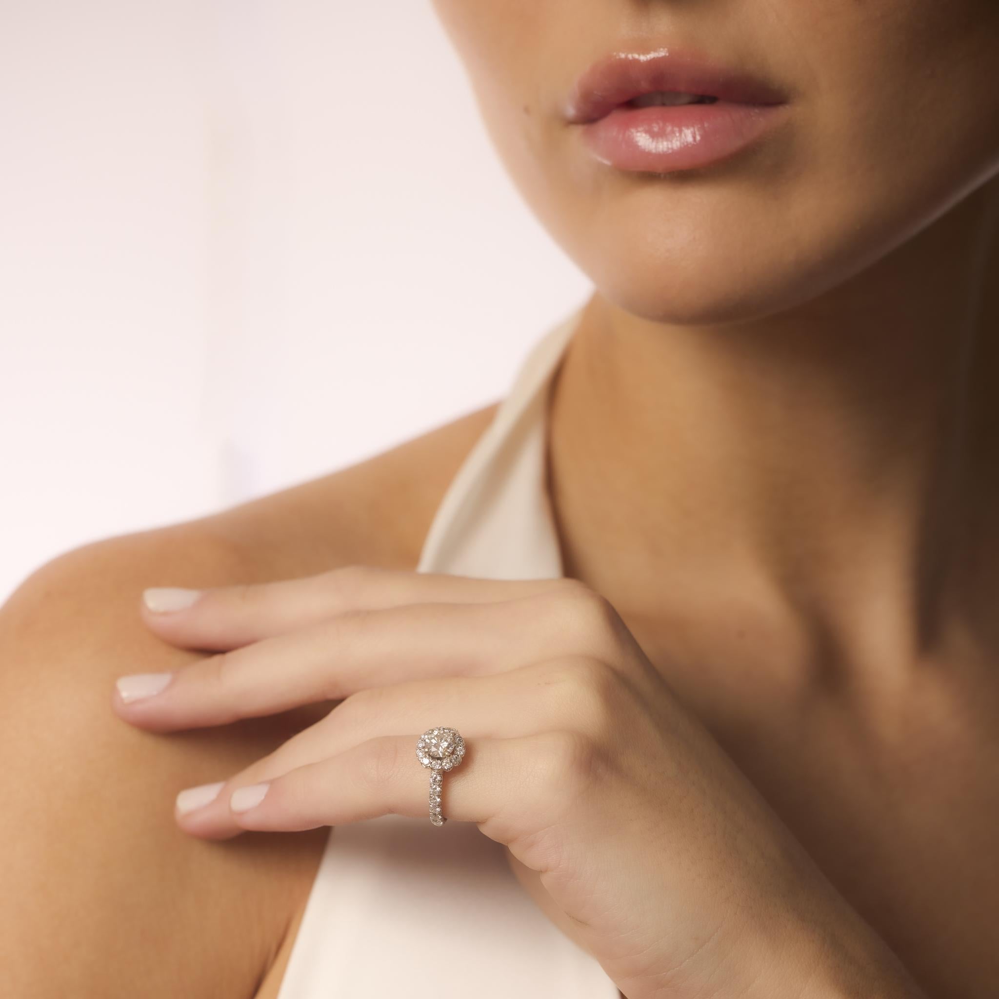 Este anillo vintage Gabriel & Co. tiene un diamante central redondo de 0,80 quilates con 24 diamantes de realce, todo engastado en reluciente oro blanco de 14 quilates con sello firmado.