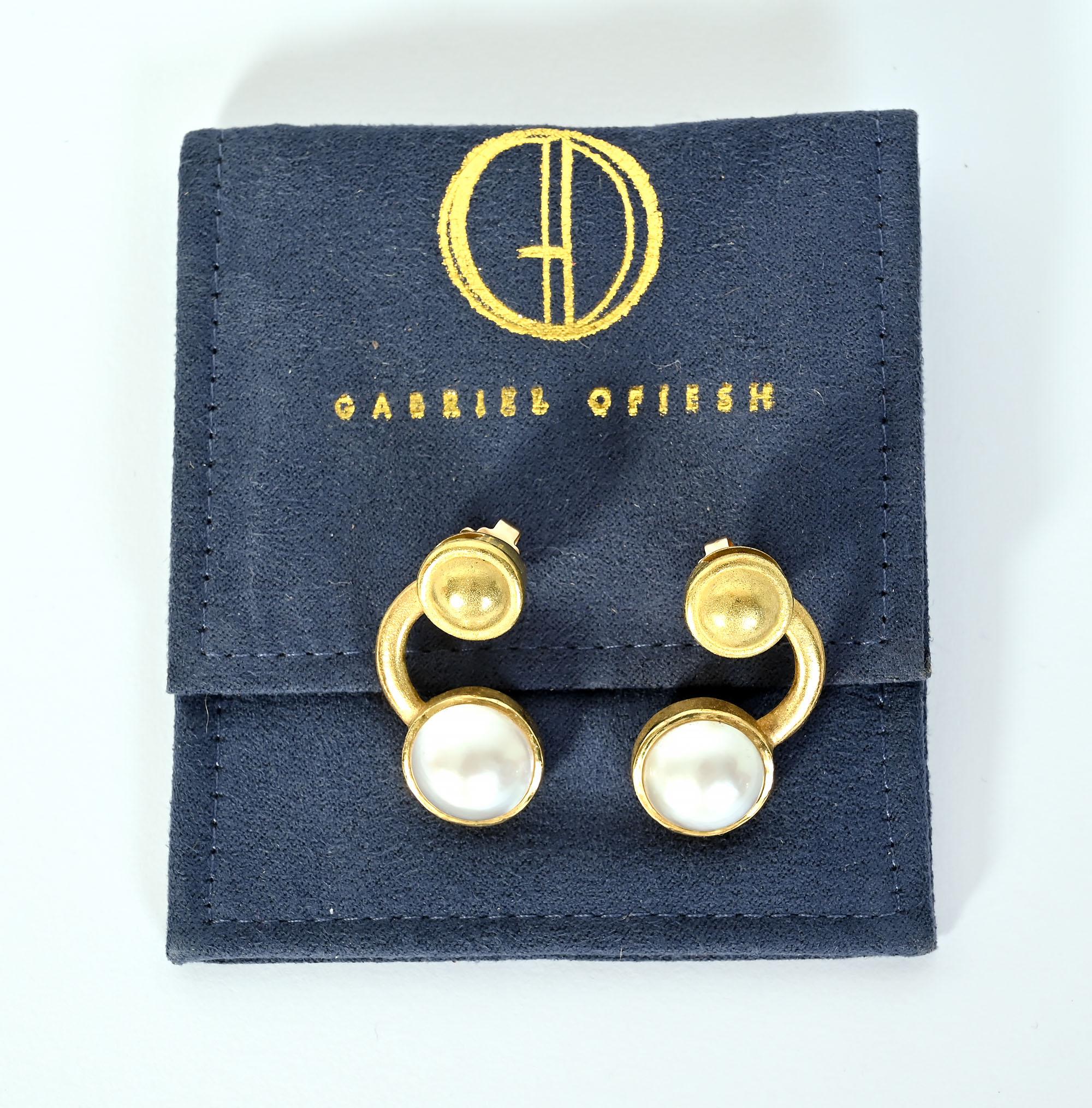 Contemporary style earrings by American jeweler, Gabriel Ofiesh. The earrings consist of a 13mm pearl in a collar bezel. On top of that is a 10mm gold dome, also with a collar bezel. The gold dome swivels. The earrings are for pierced ears. They