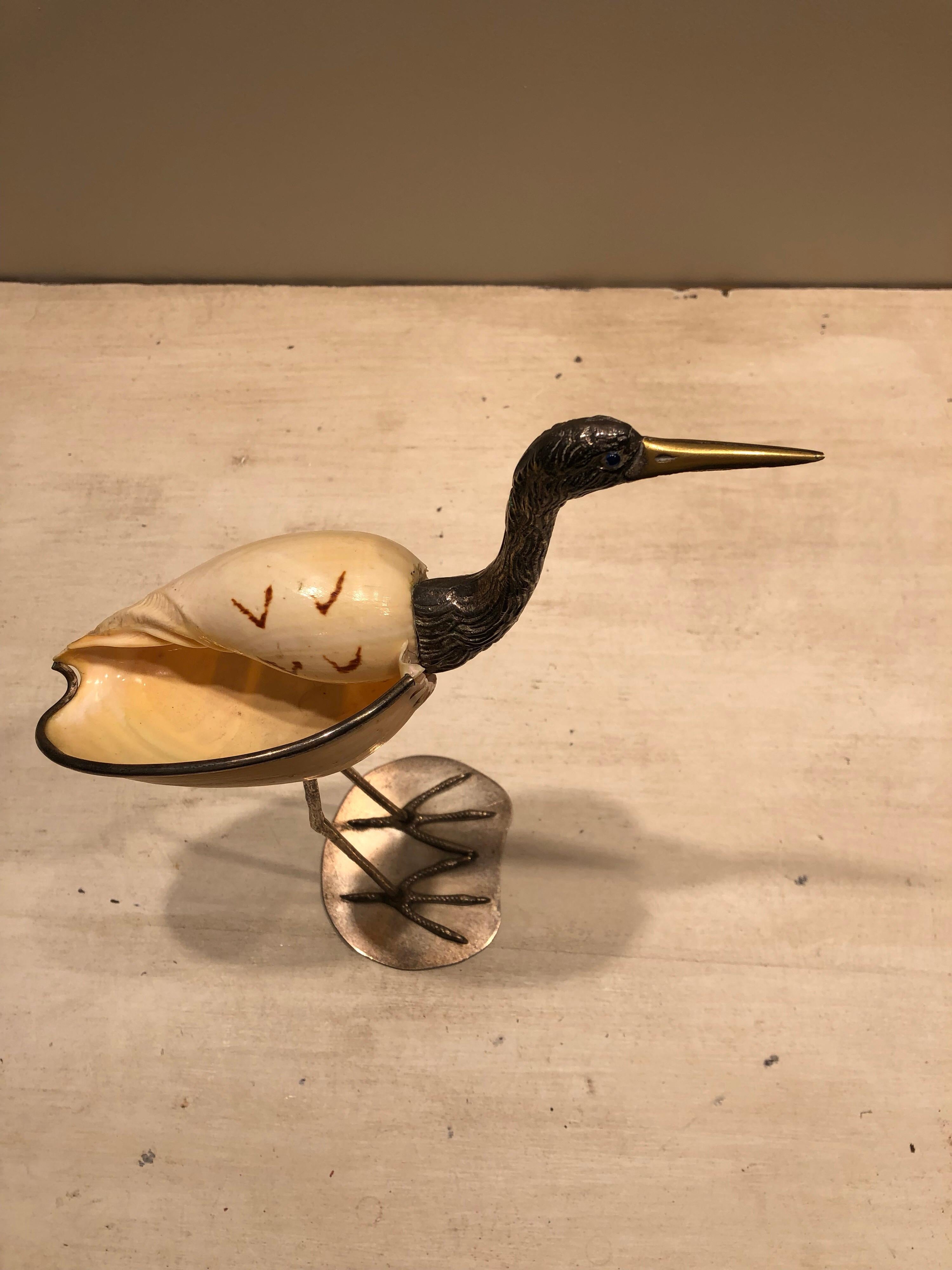 A gorgeous Italian 1970s bird sculpture by Gabriella Binazzi made of silver plated brass and a seashell. It has striking blue eyes and is handcrafted with the original paper label attached and a signature on the underside 