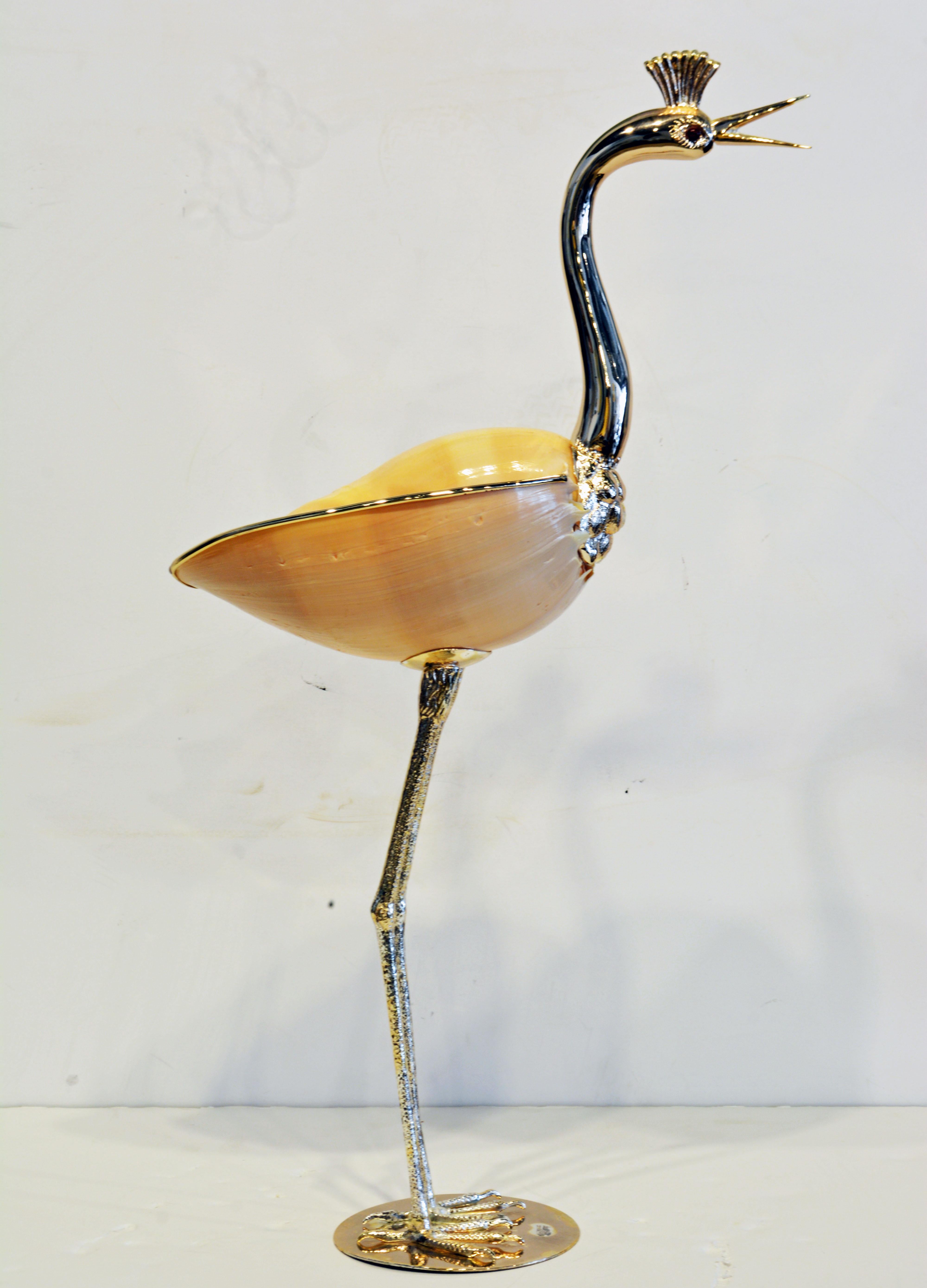 Designed by Gabriella Binazzi of Italy this beautiful bird, a crane, stands almost 22 inches tall and consists of a natural sea shell with silver plated neck, head and legs. The base bears the etched brand name.