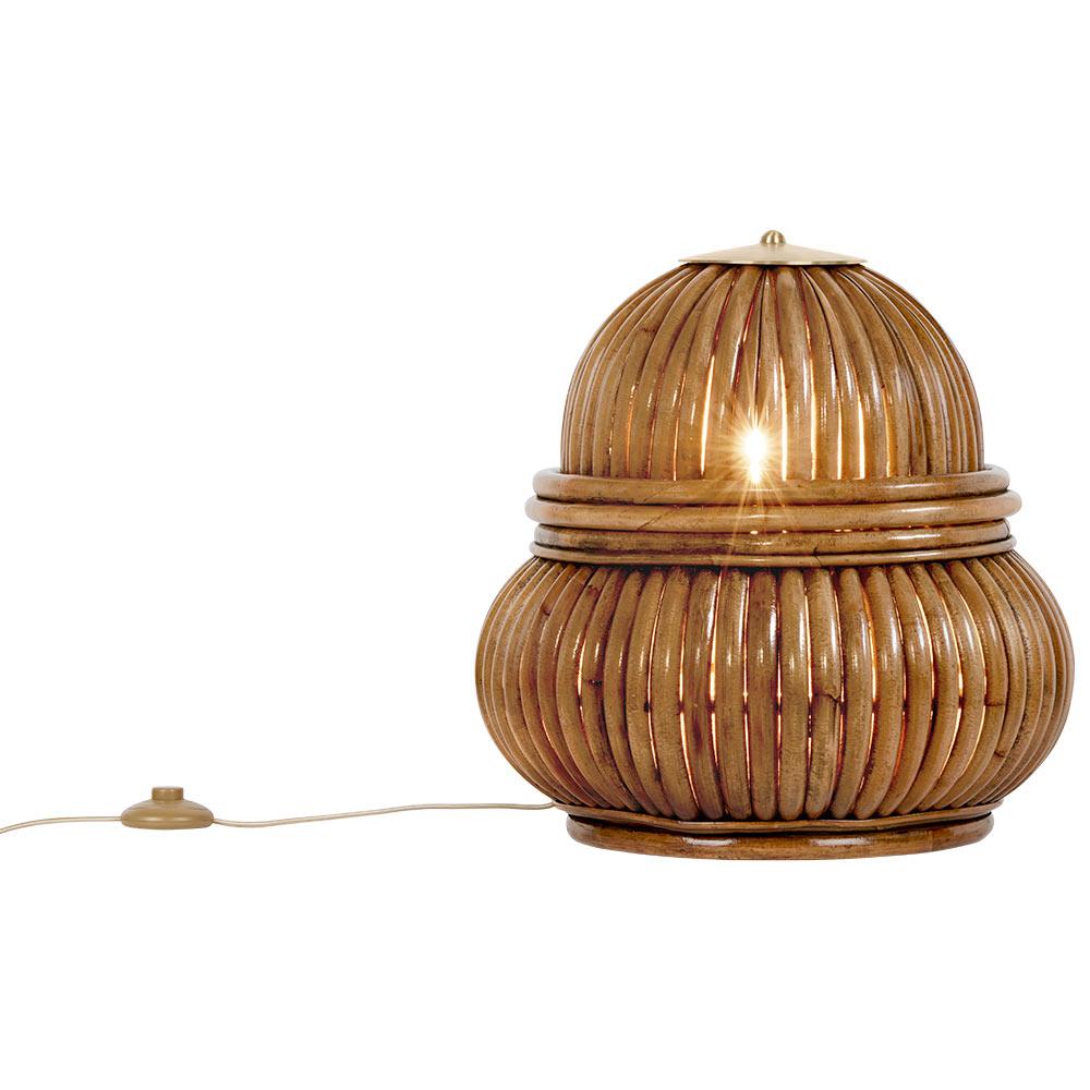 The floor lamp has a shade formed from a vertical arrangement of rattan strips, with brass detailing. The pattern of the strips allows the lamp to cast a beautifully delicate play of light and shade on the floor around it, evoking an atmosphere of