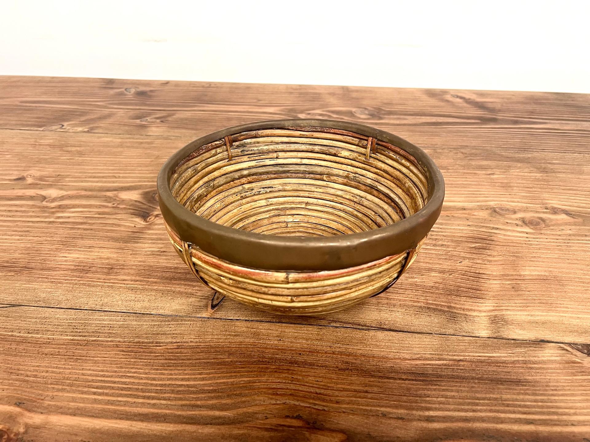 Verschönern Sie Ihr Interieur mit dieser Obstschale von Gabriella Crespi, einem emblematischen Stück italienischen Designs aus den 1970er Jahren. Diese Kreation, bei der geflochtenes Rattan mit der goldenen Wärme von Messing kombiniert wird,