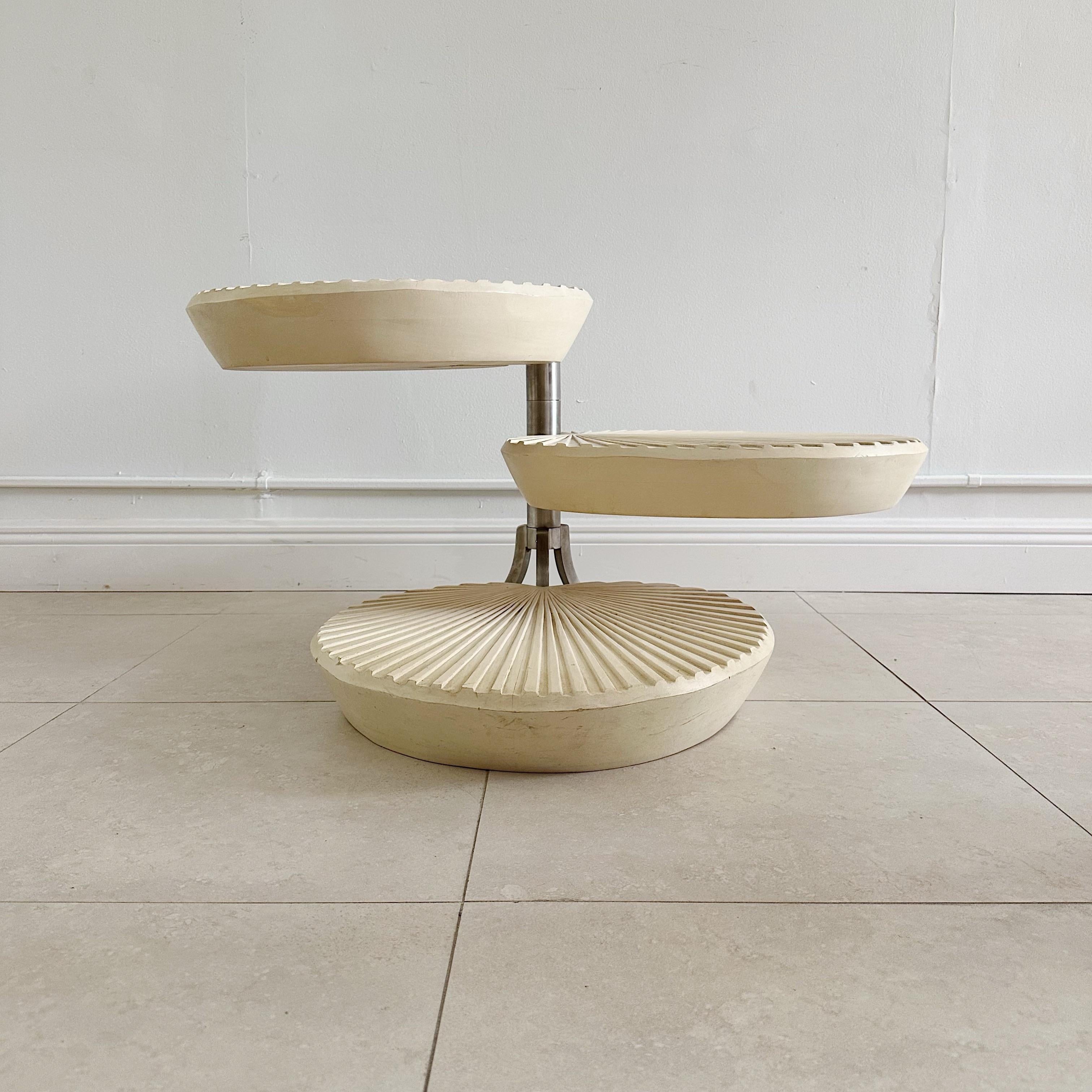 Mesa auxiliar, de centro o de cóctel giratoria de tres niveles. Las mesas son de madera, con pata de apoyo giratoria de acero. Acabado original con desgaste en la superficie, marcas y arañazos. Presenta una pátina muy desgastada y envejecida. Las