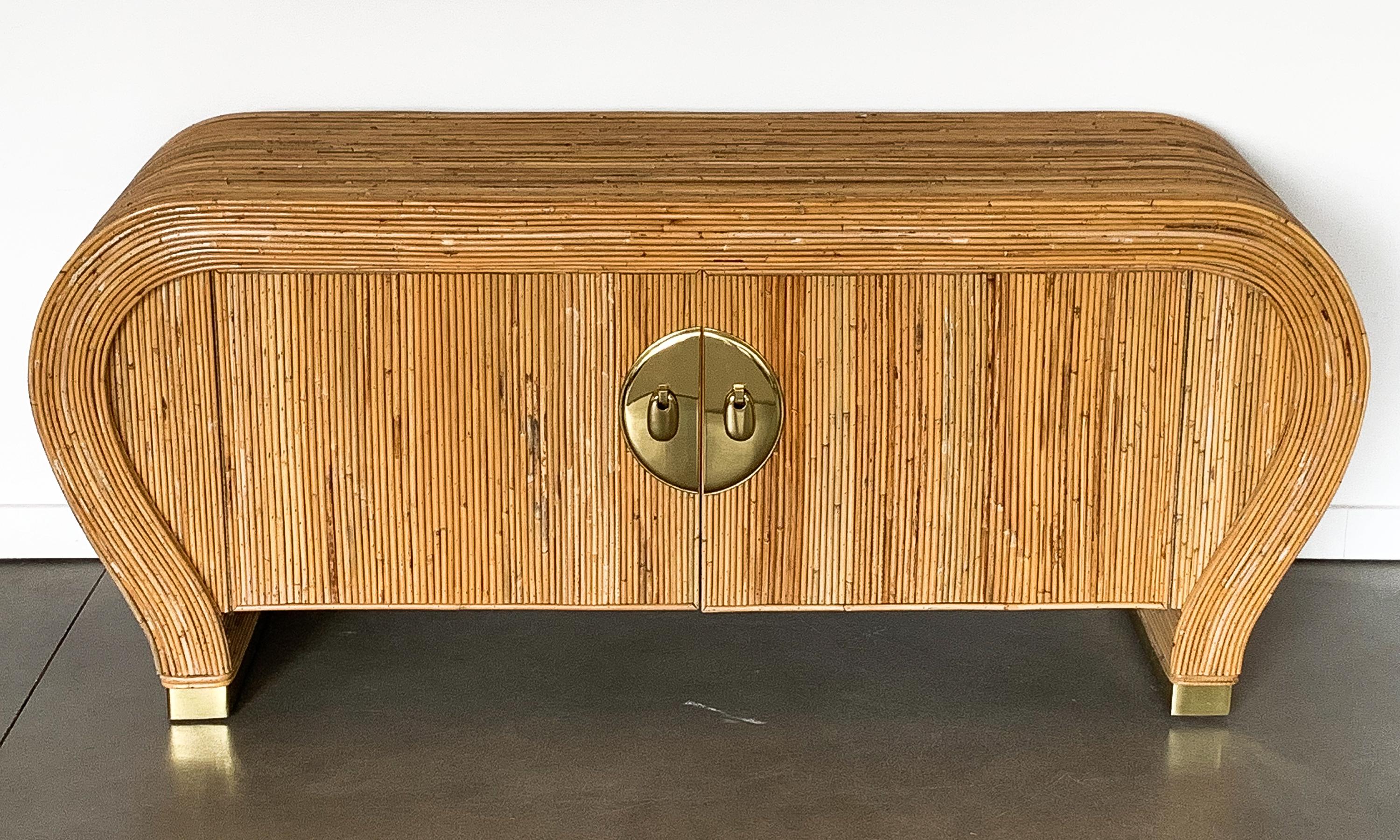 A very unique and uncommon split pencil reed / bamboo sideboard cabinet, circa 1980. Attributed to Vivai Del Sud.  This stunning sideboard features a waterfall form wrapped with split pencil reed / bamboo. Finished on all sides. Brass circular door