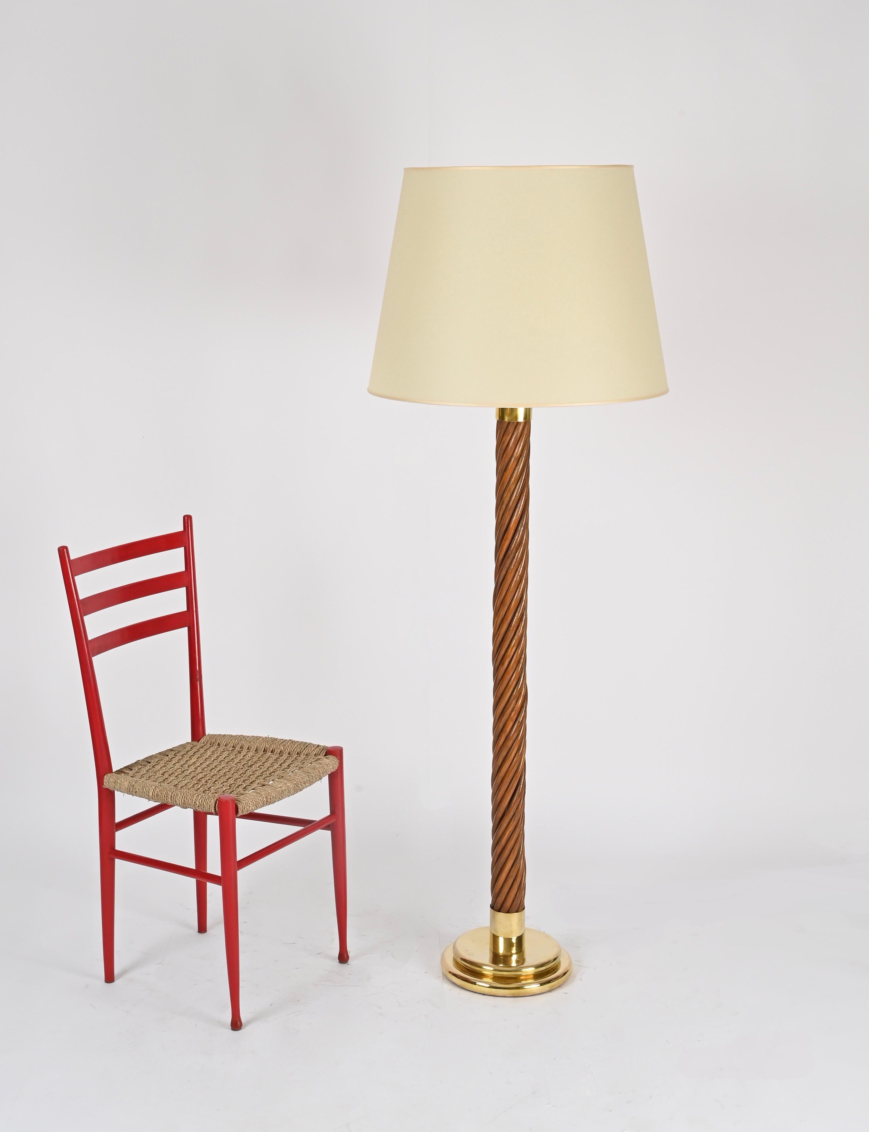 Superbe et unique lampadaire Mid-Century entièrement fabriqué à la main en rotin torsadé et laiton massif, complété par un abat-jour en papier parchemin. Cette merveilleuse pièce a été produite en Italie dans les années 1960, en suivant clairement