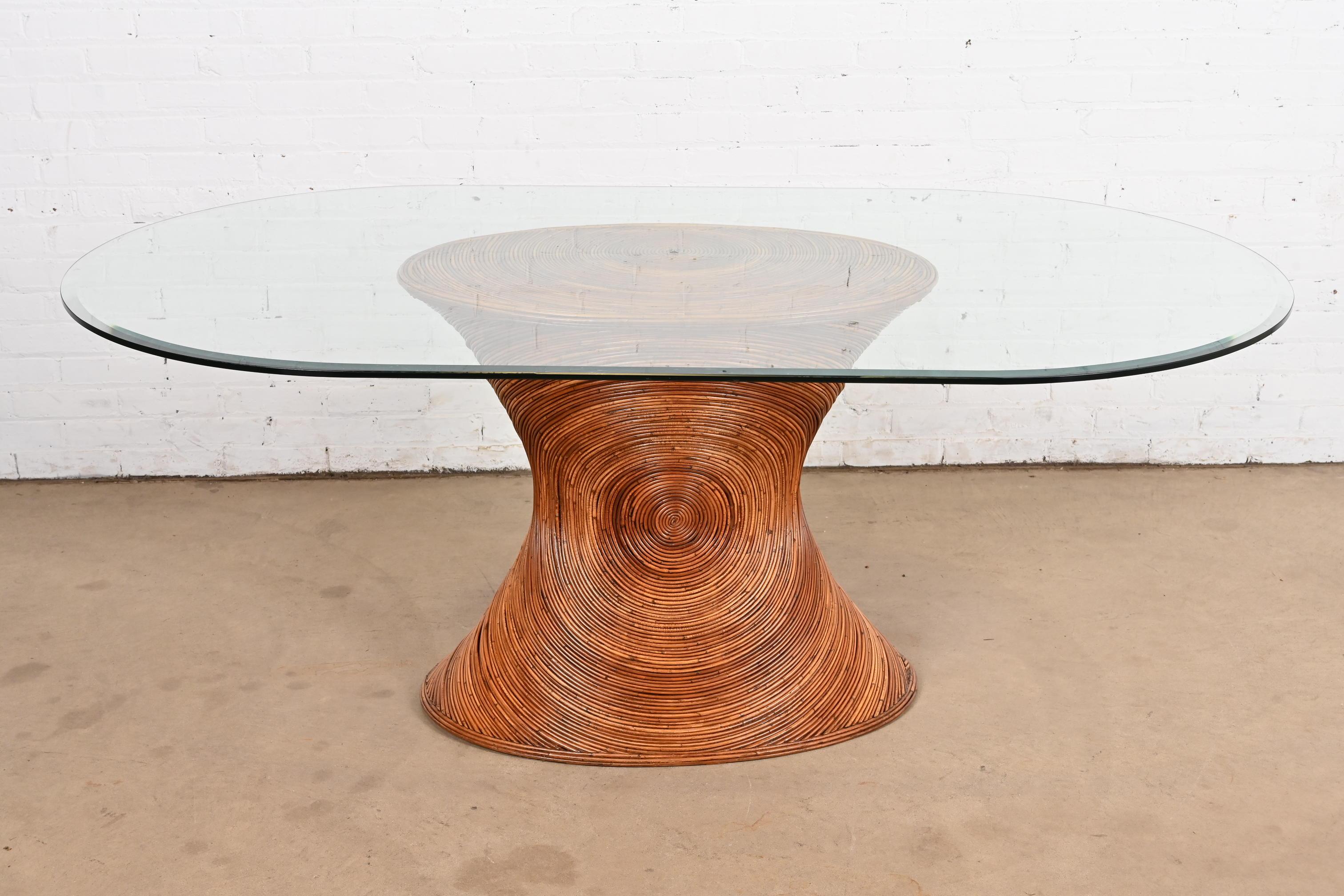 An exceptional mid-century Organic Modern coastal dining table

In the manner of Gabriella Crespi

USA, Circa 1970s

Gorgeous hourglass-shaped pencil reed rattan base, with oval beveled glass top.

Measures: 71.75