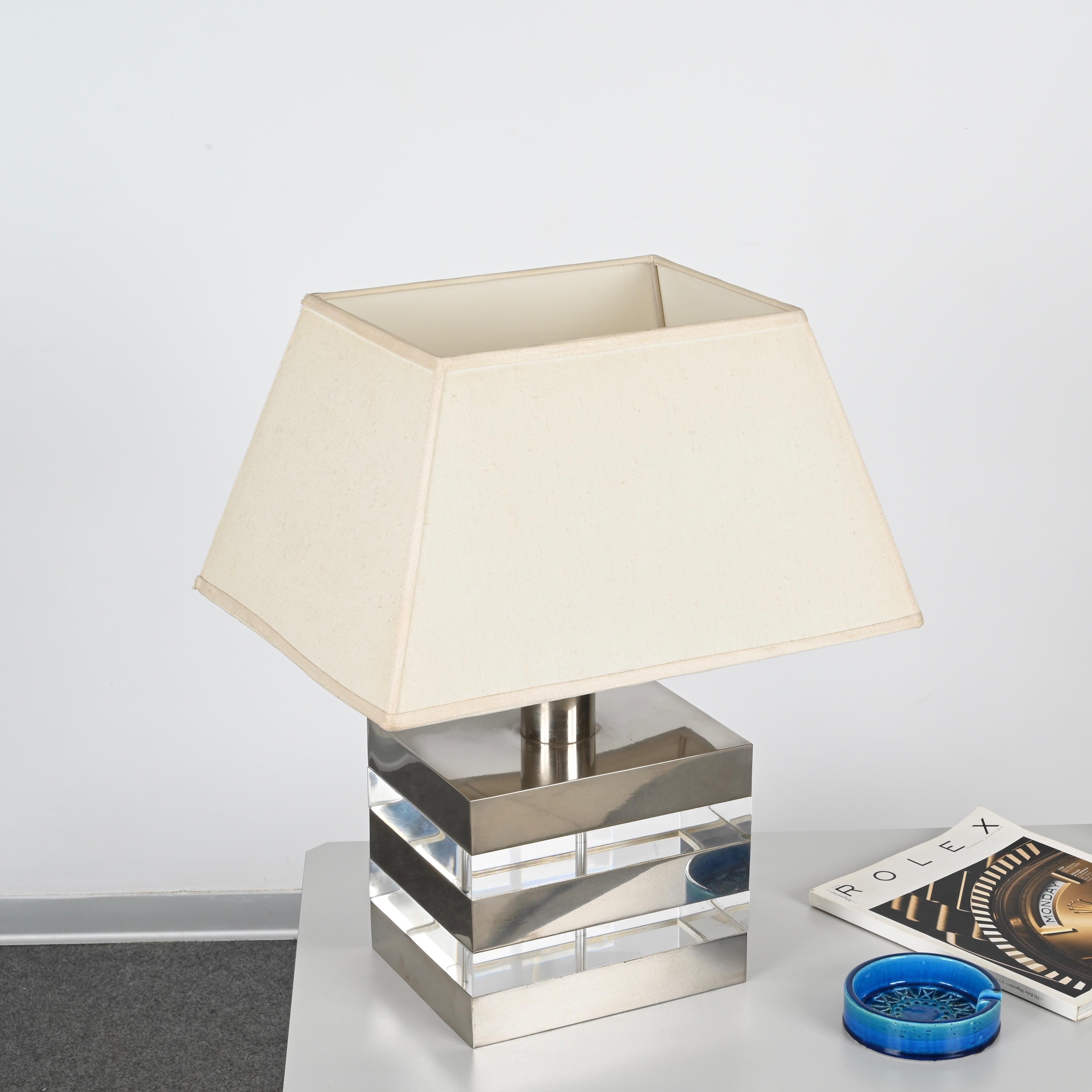 Maravillosa lámpara de sobremesa de mediados de siglo fabricada con un único bloque de lucita transparente y acero cromado. Esta impresionante lámpara se fabricó en Italia durante la década de 1970, siguiendo claramente el estilo de Gabriella