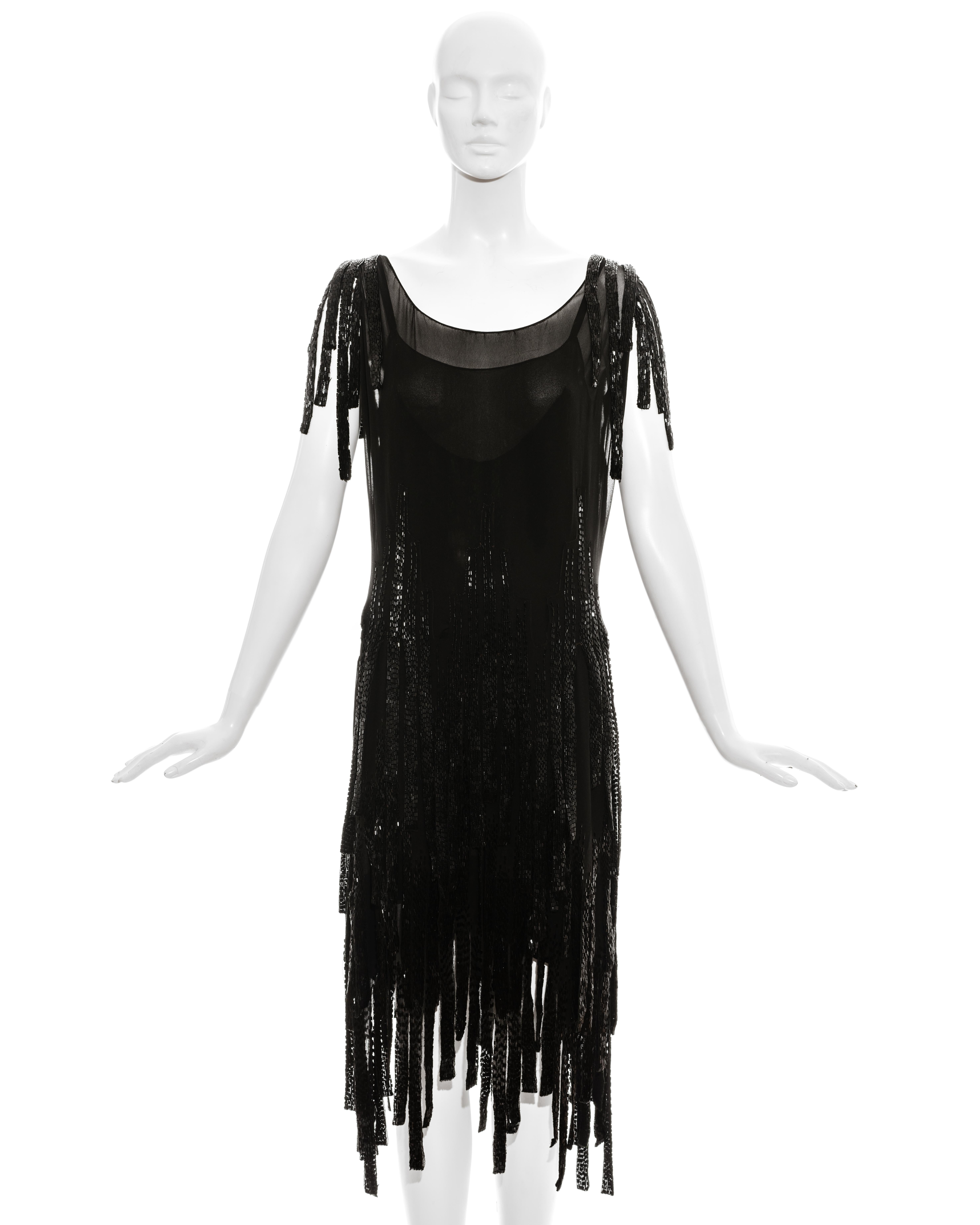 Gabrielle Chanel couture black silk flapper dress comprising two shifts with glass beaded hanging strands around shoulders and skirt.  Classic 1920s style with drop waist. 

c. 1924-1926

* Condition report upon request 