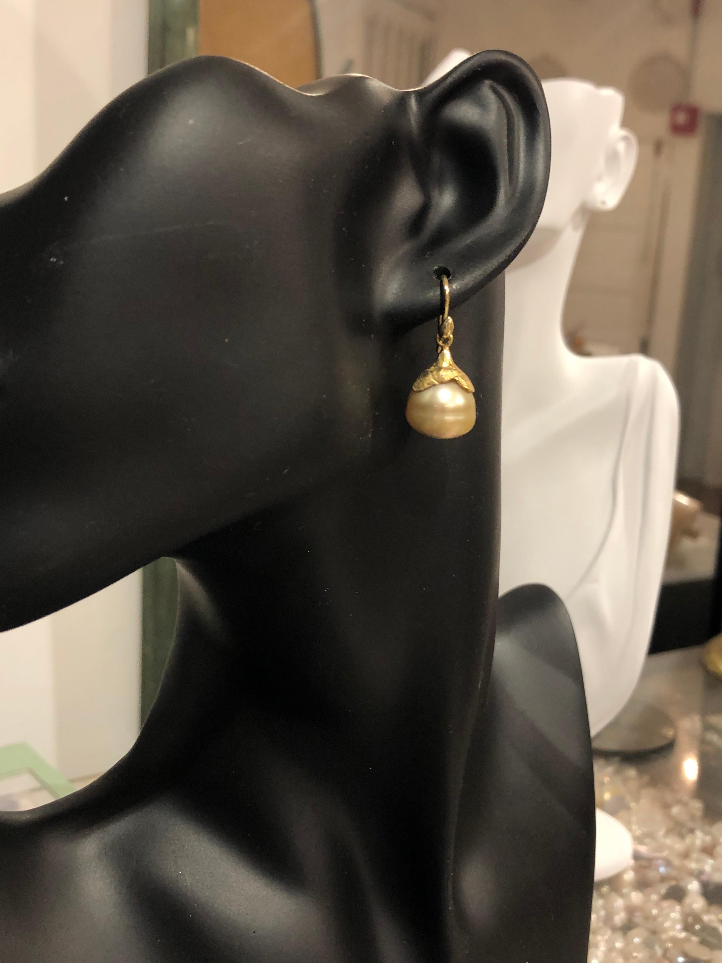 Dramatic, buttery-golden teardrop South Sea pearls are a uniquely beautiful shape. Held by Gabrielle's 18k petal cap and smooth seed earwires. 13x12.8mm pearls.