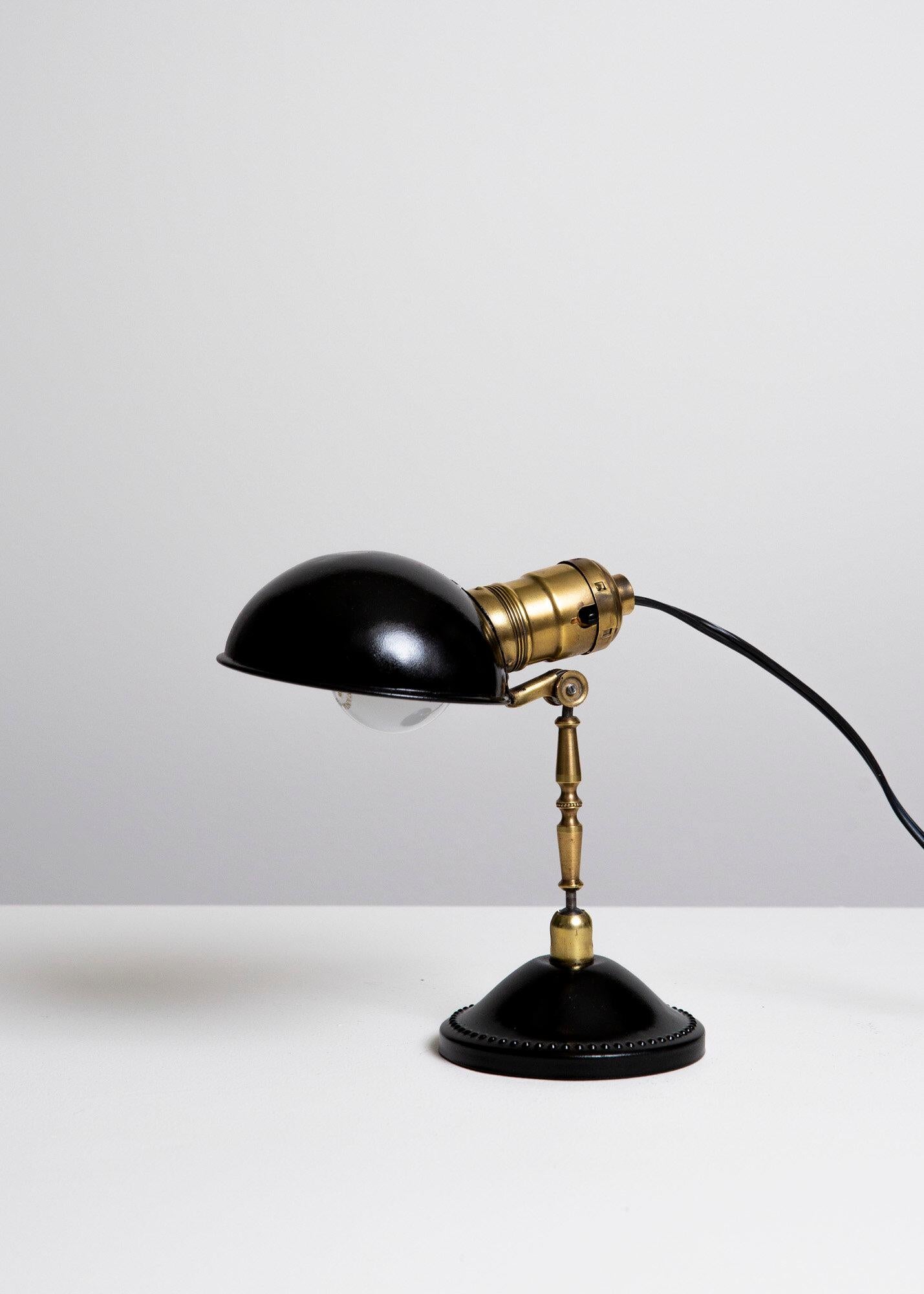Una popolare lampada a clip dell'epoca che può essere appoggiata su un tavolo, agganciata a una parete o a una scrivania e ripiegata su se stessa. E-26 Edison a incandescenza media 40 watt max o superiore se LED/CFL.

Accensione e spegnimento  Presa