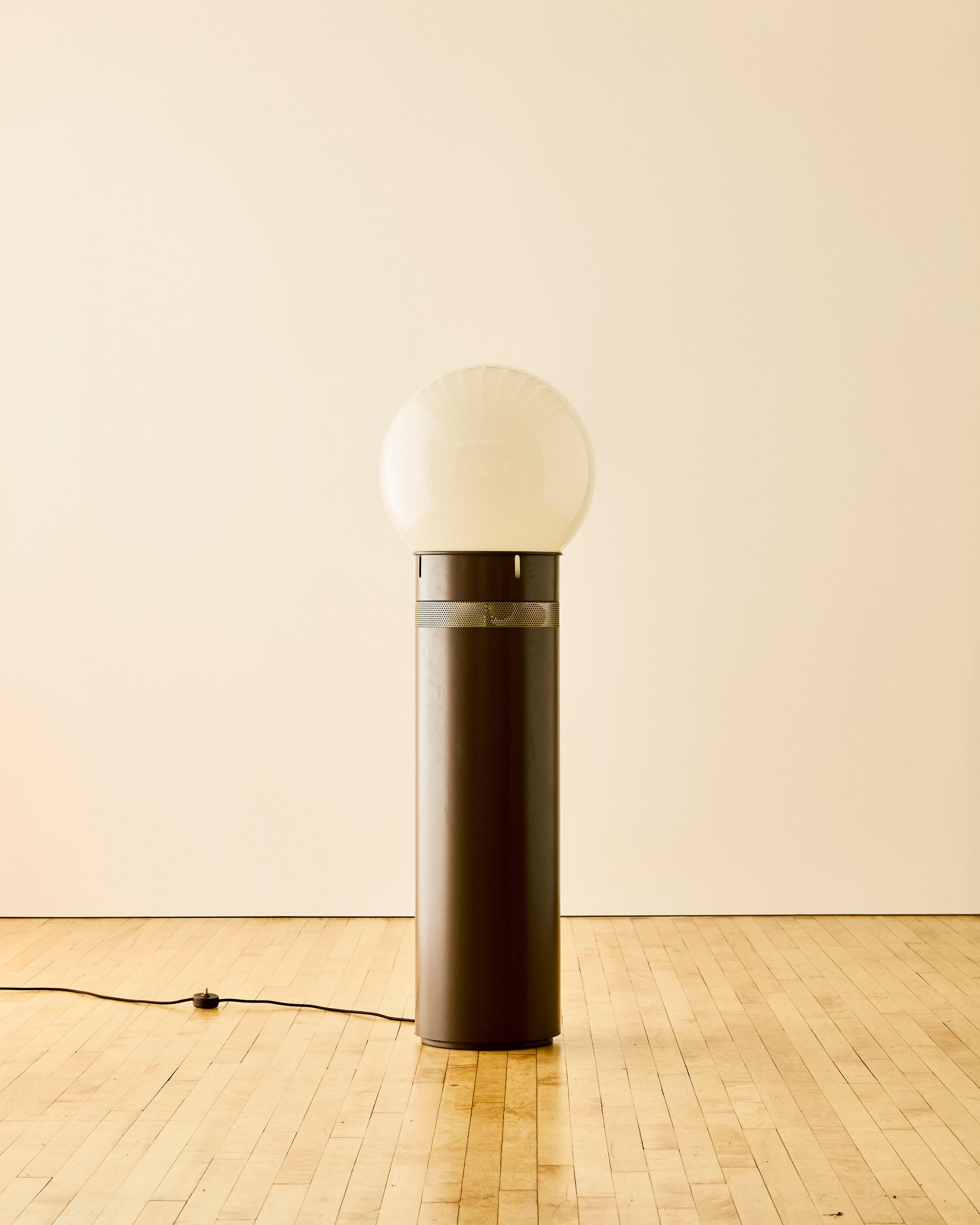 Gae Aulenti floor lamp for Artemide Oracolo with an enameled aluminum column base with a perforated steel element design near the upper base and a hand blown glass orb shade.