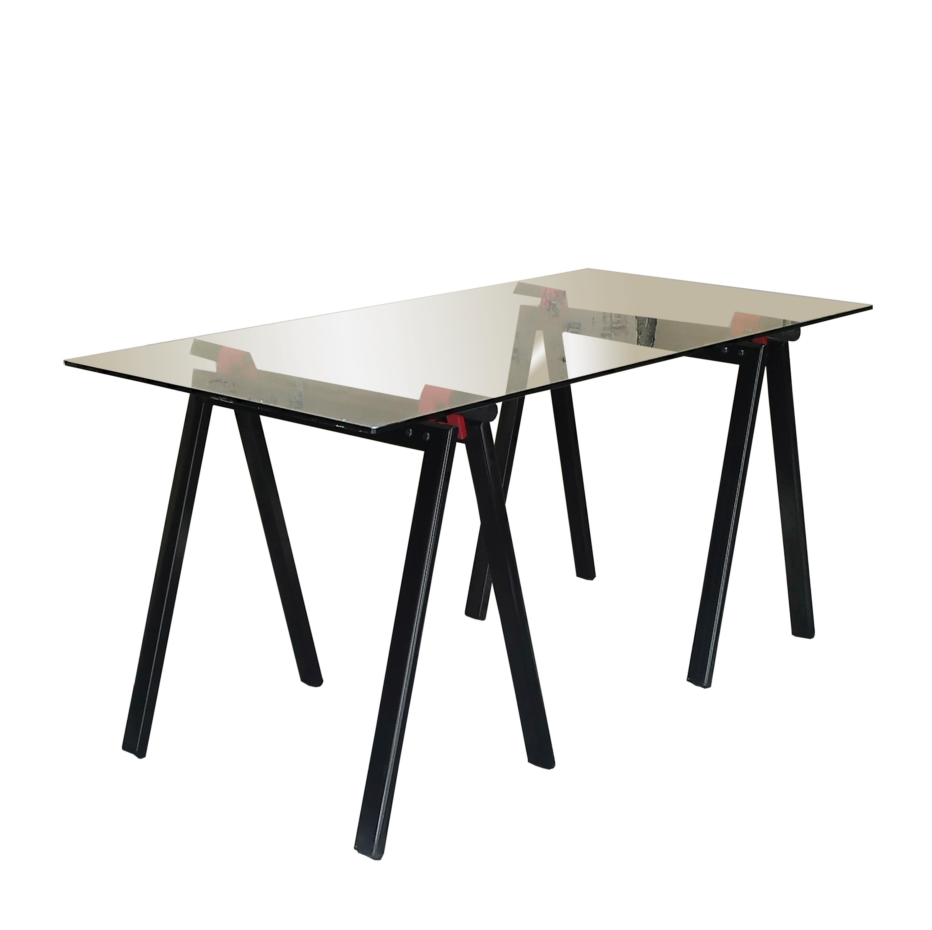 Mesa de trabajo Gaetano de Gae Aulenti para Zanotta con original tablero de cristal apoyado en dos caballetes abatibles de metal esmaltado en negro y rojo.
Objeto intemporal. Con su diseño seco y esencial, combina modernidad y elegancia. Puede