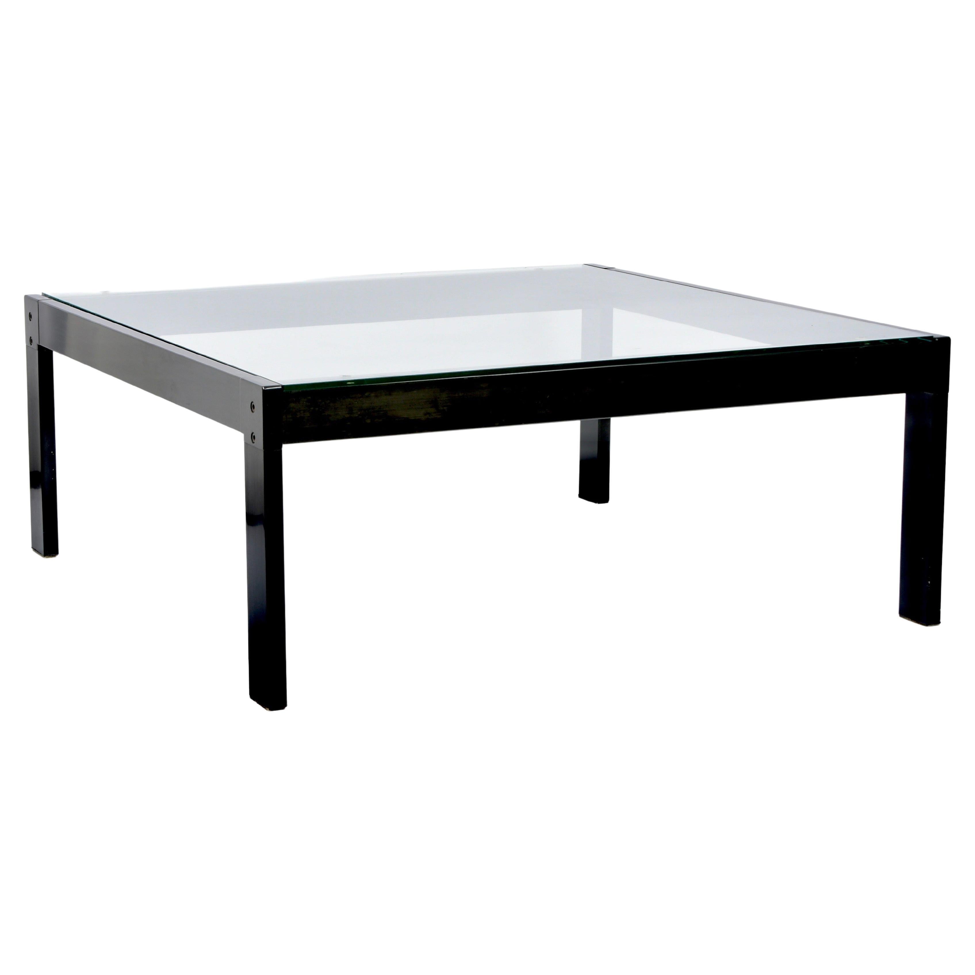 Increíble mesa de centro de cristal y metal negro esmaltado de mediados de siglo. Esta fantástica pieza fue diseñada en Italia por Gae Aulenti para Zanotta durante la década de 1970.

Esta espléndida mesa de líneas rectas y limpia estructura de