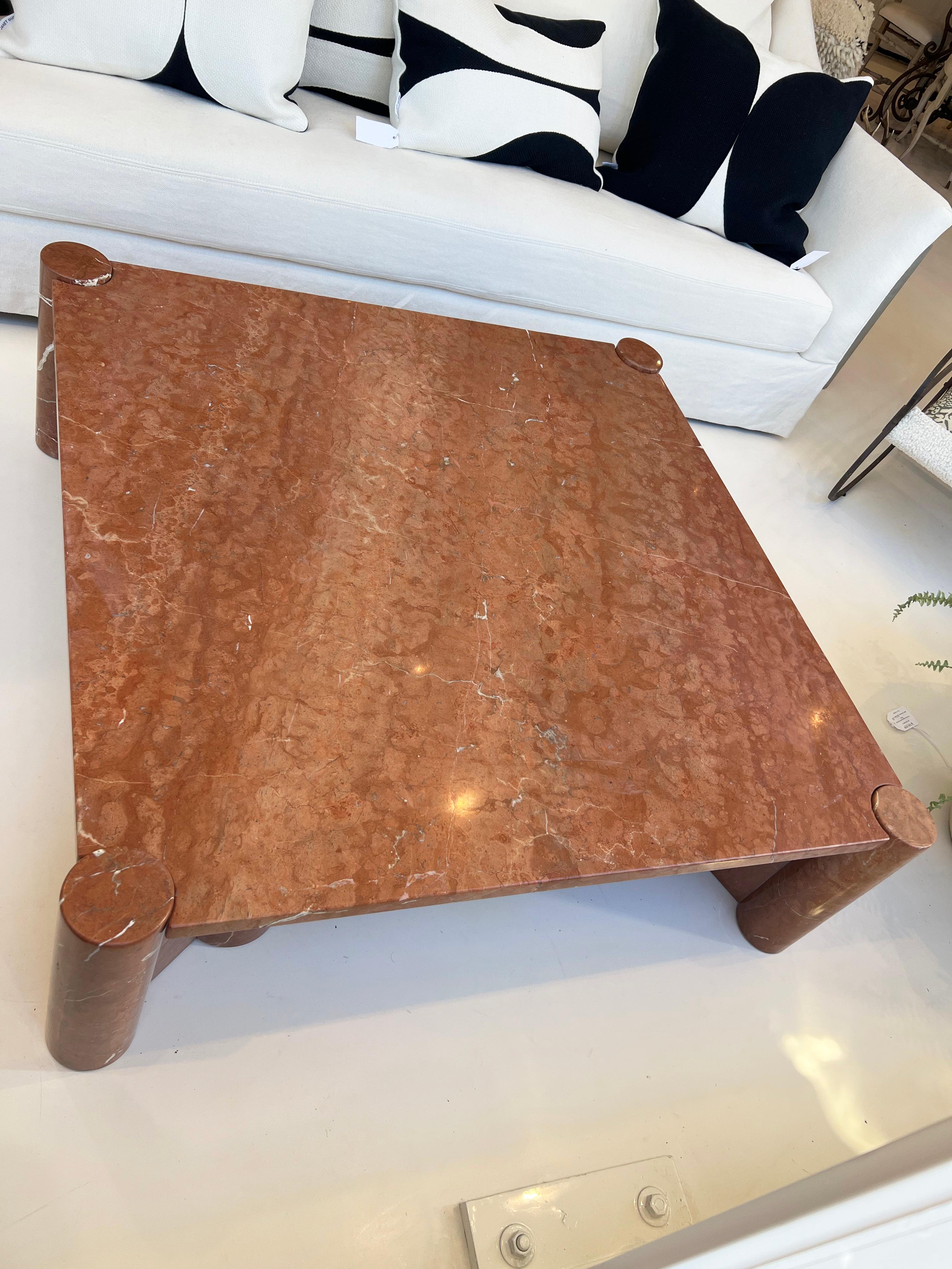 Fine mid-century over-size coffee table by Gae Aulenti. Beautiful Rossa Alicante marble square slab on cylindrical legs at each corner. Definitely an attention getting addition to any room and decor style.