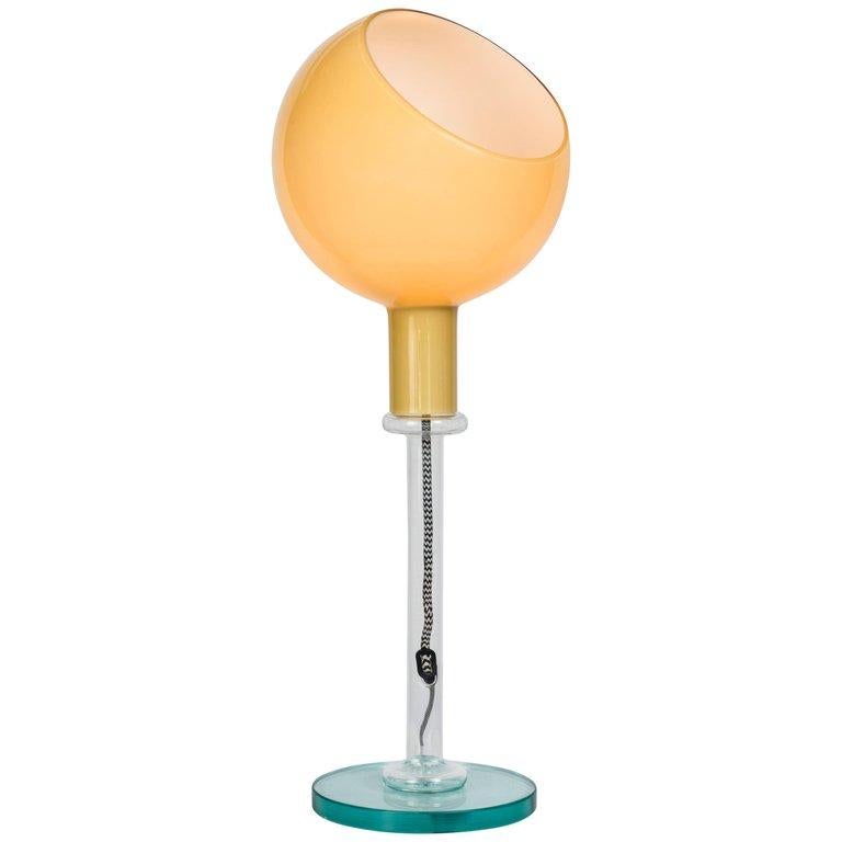 Gae Aulenti & Piero Castiglioni 'Parola' table lamp for Fontana Arte features three different kinds of glass working processes: opaline blown glass for the adjustable shade, natural glass for the stem and natural beveled crystal for the base. It is