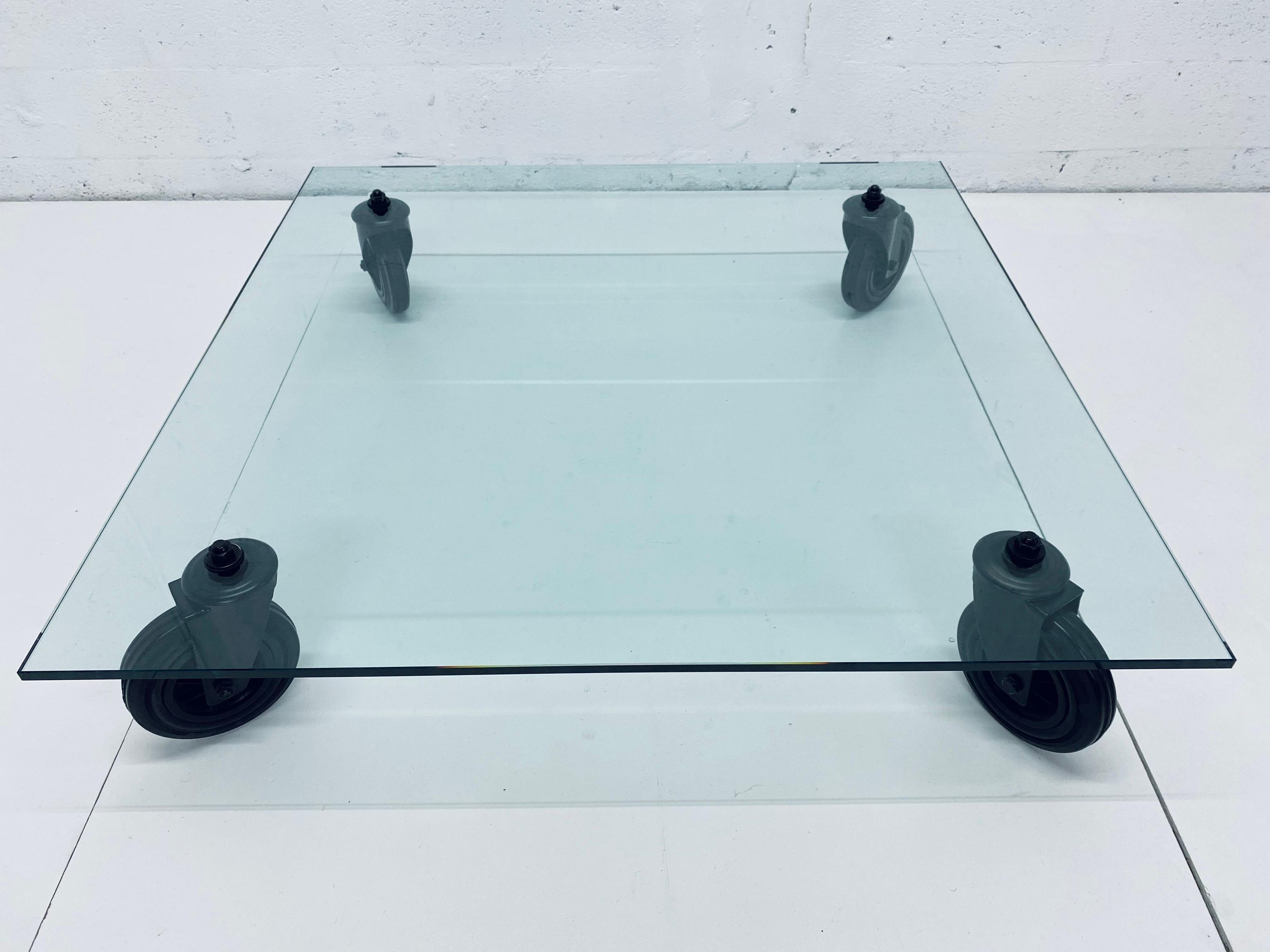 Designed by Gae Aulenti, this low coffee table consists of a tempered glass top supported by four black industrial wheels and was produced by Fontana Arte and imported by Luminaire.

An Industrial trolley used at the Fontana Arte plant to