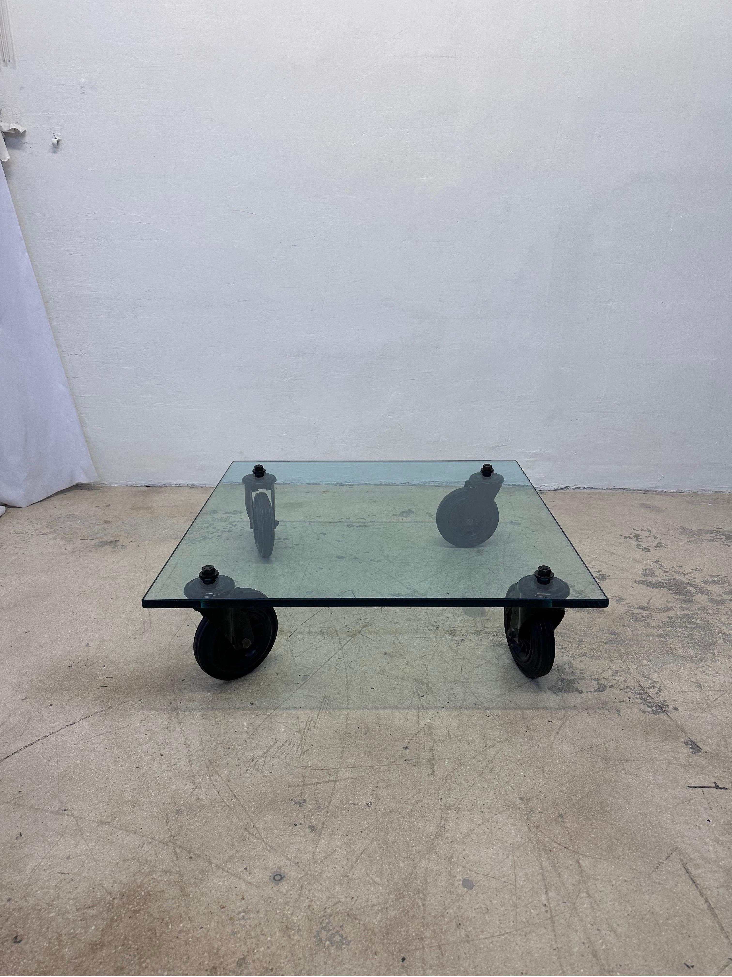 Designed by Gae Aulenti, this low coffee table consists of a tempered glass top supported by four black industrial wheels and was produced by Fontana Arte and imported by Luminaire.

An Industrial trolley used at the Fontana Arte plant to transport