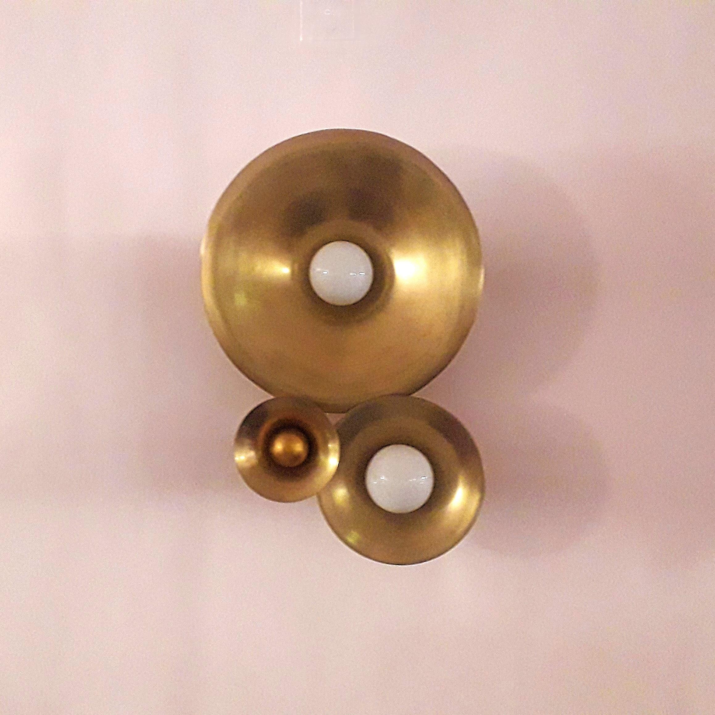 L'applique Gaé Trio presenta tre dischi circolari in ottone in una composizione sfalsata, tutti rifiniti in ottone patinato oro invecchiato. La disposizione sovrapposta crea un ritmo visivo che ricorda i cimbali raggruppati su una parete.

Due dei