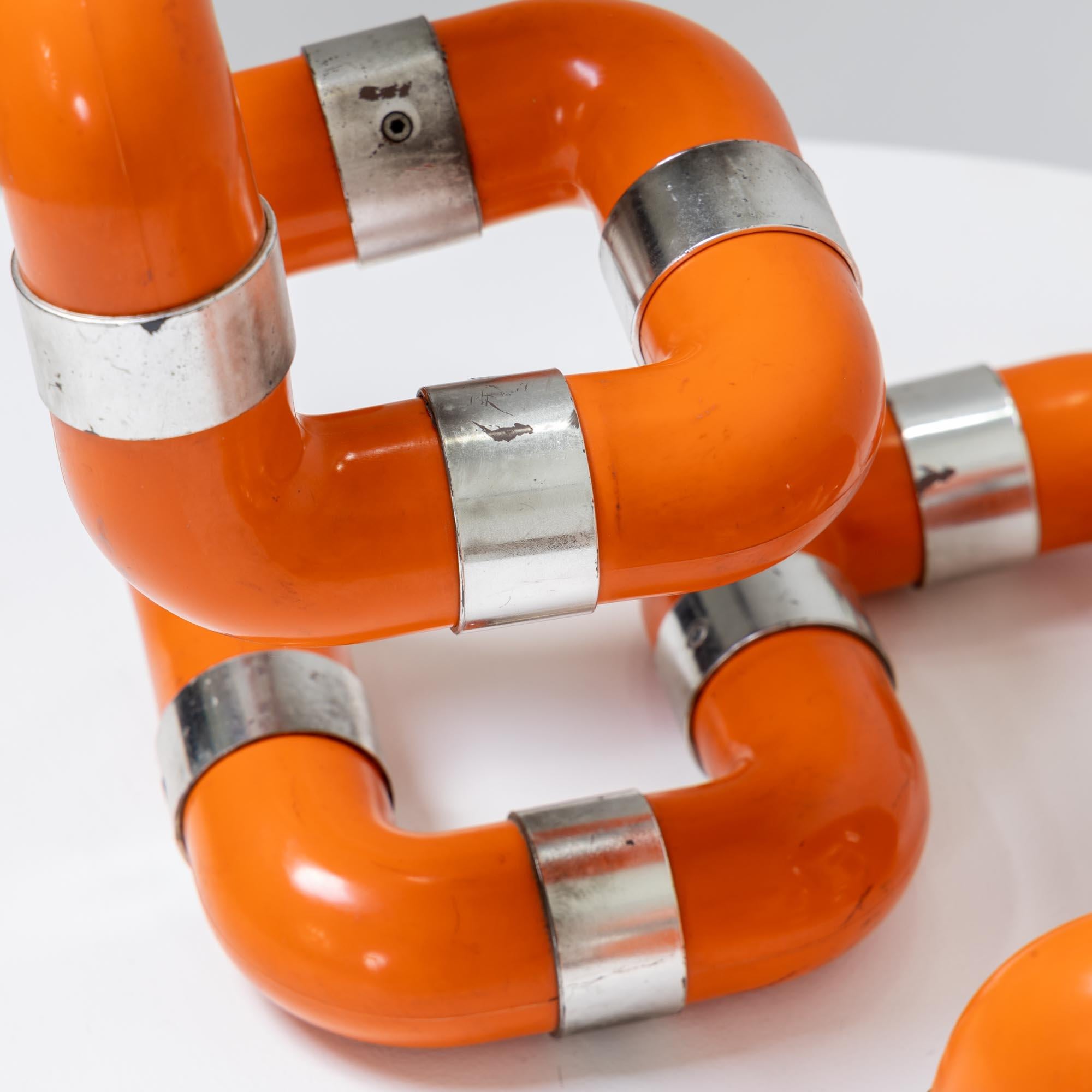 Zwei Rombo-Tischleuchten von Gaetano Missaglia aus L-förmigen orangefarbenen Kunststoffrohren mit verchromten Anschlüssen und je einer Fassung. Wir übernehmen keine Haftung oder Gewährleistung für die Elektrifizierung.