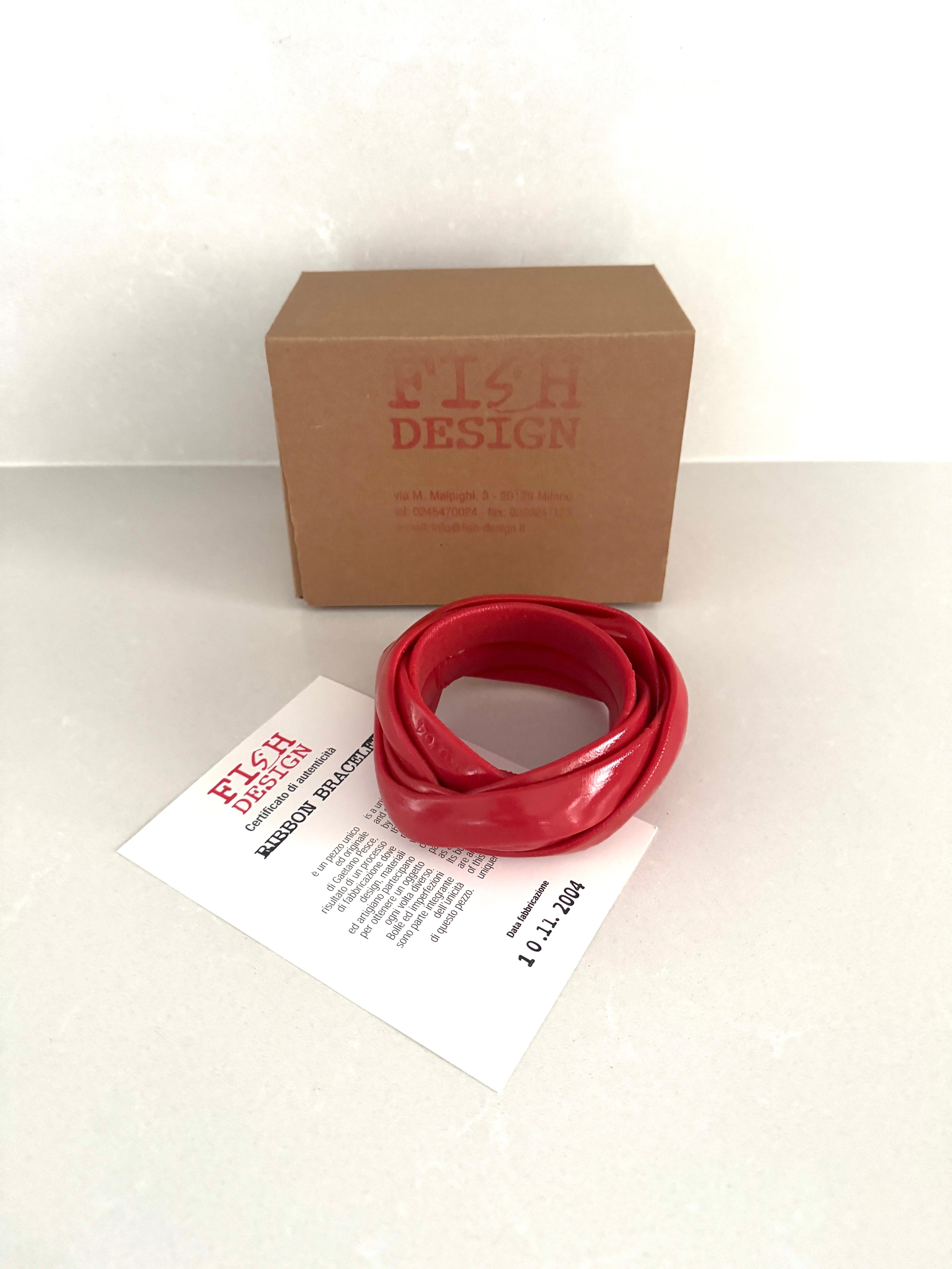 Armband aus der Serie 'Ribbon', entworfen von Gaetano Pesce und hergestellt von Fish Design am 10/11/2004

Es ist ein einzigartiges und originelles Stück, das das Ergebnis eines Herstellungsprozesses ist, bei dem Design, Materialien und