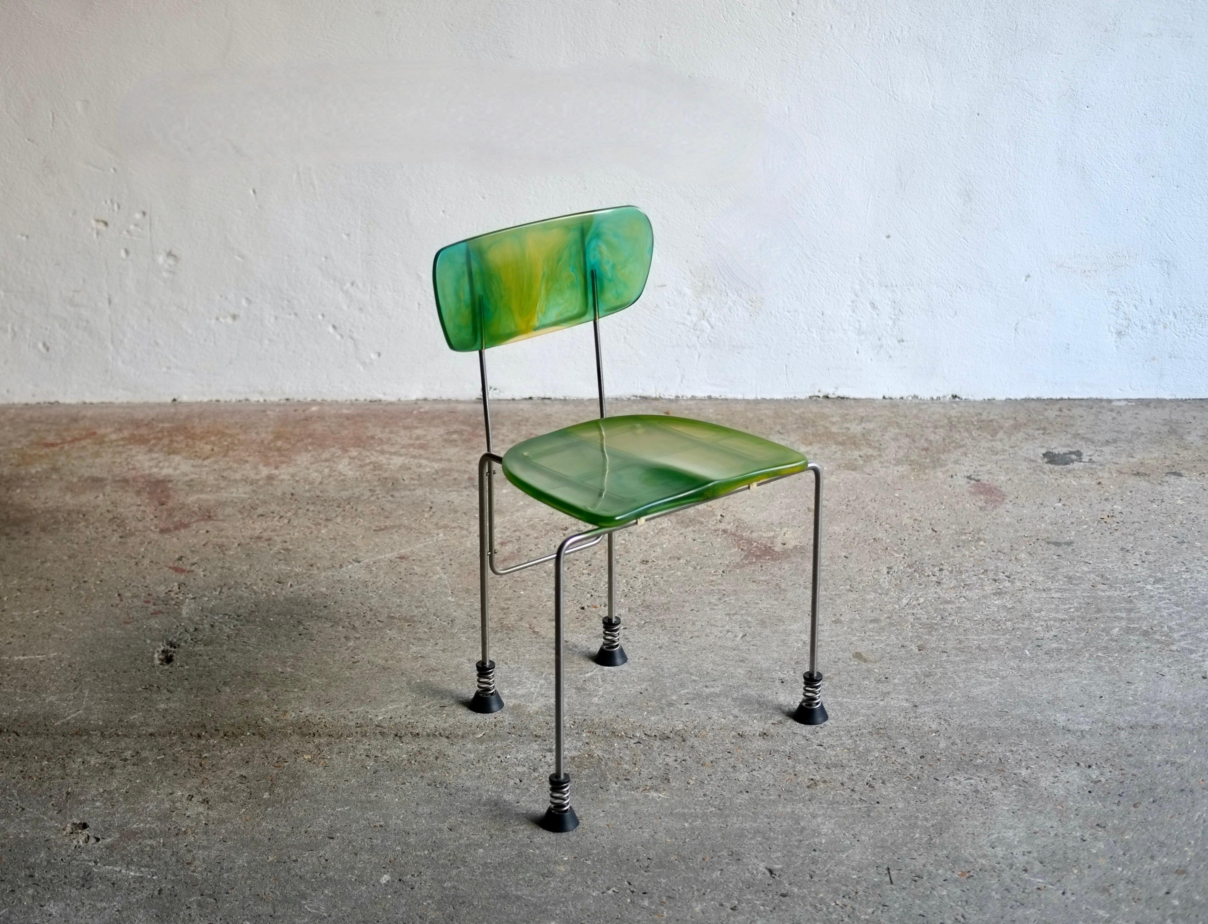 Broadway chair designed by Gaetano Pesce for Bernini, 1993.

Green and blue toned resin moulded plastic with brushed steel legs.

In good solid condition. There is a mark on the seat where the internal screw is (see photo) when you rub your finger