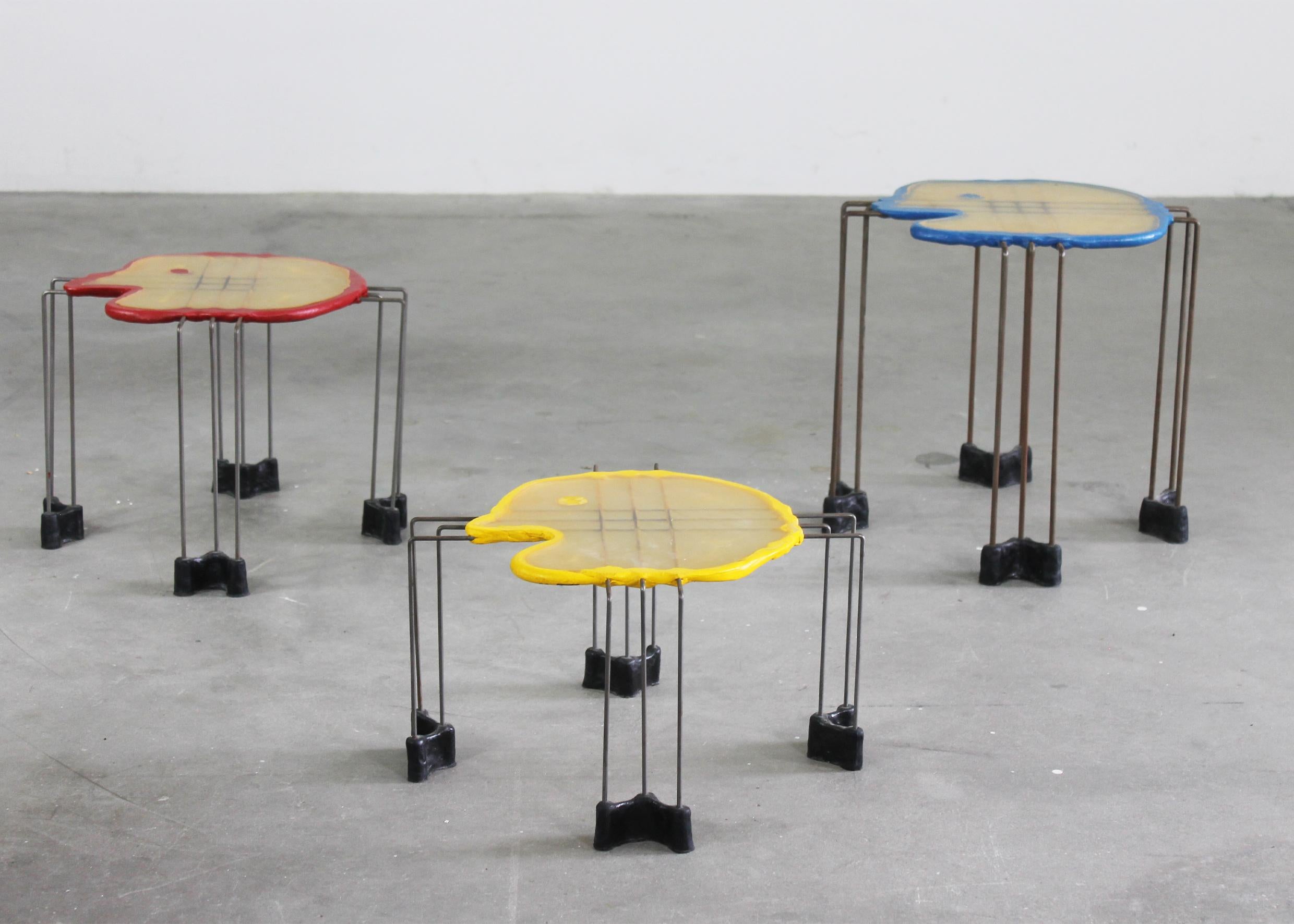 Set of three nesting tables with structure in steel, feet, and table tops in resin, designed by Gaetano Pesce and produced by Fish Design in 1999. 

Dimensions:
Blue; H38,5 x 40 x 40 cm 
Red; H30 x 40 x 40 cm 
Yellow; H23 x 40 x 40 cm 

Gaetano