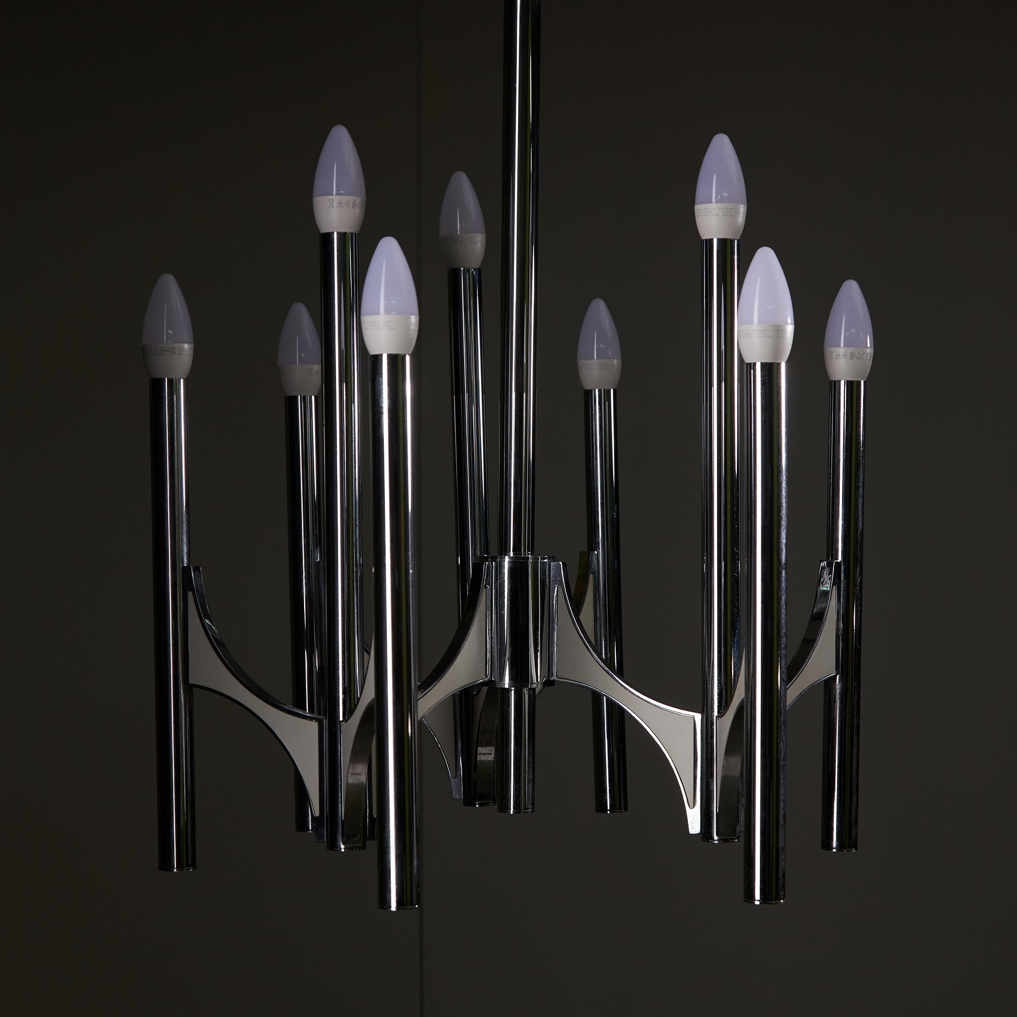 Exemple élégant du design-Light du milieu du siècle, ce lustre à 9 branches de Gaetano Sciolari allie une forme sculpturale à une matérialité raffinée.  Le cadre est en chrome et associé à des accents en aluminium de couleur crème, élégamment