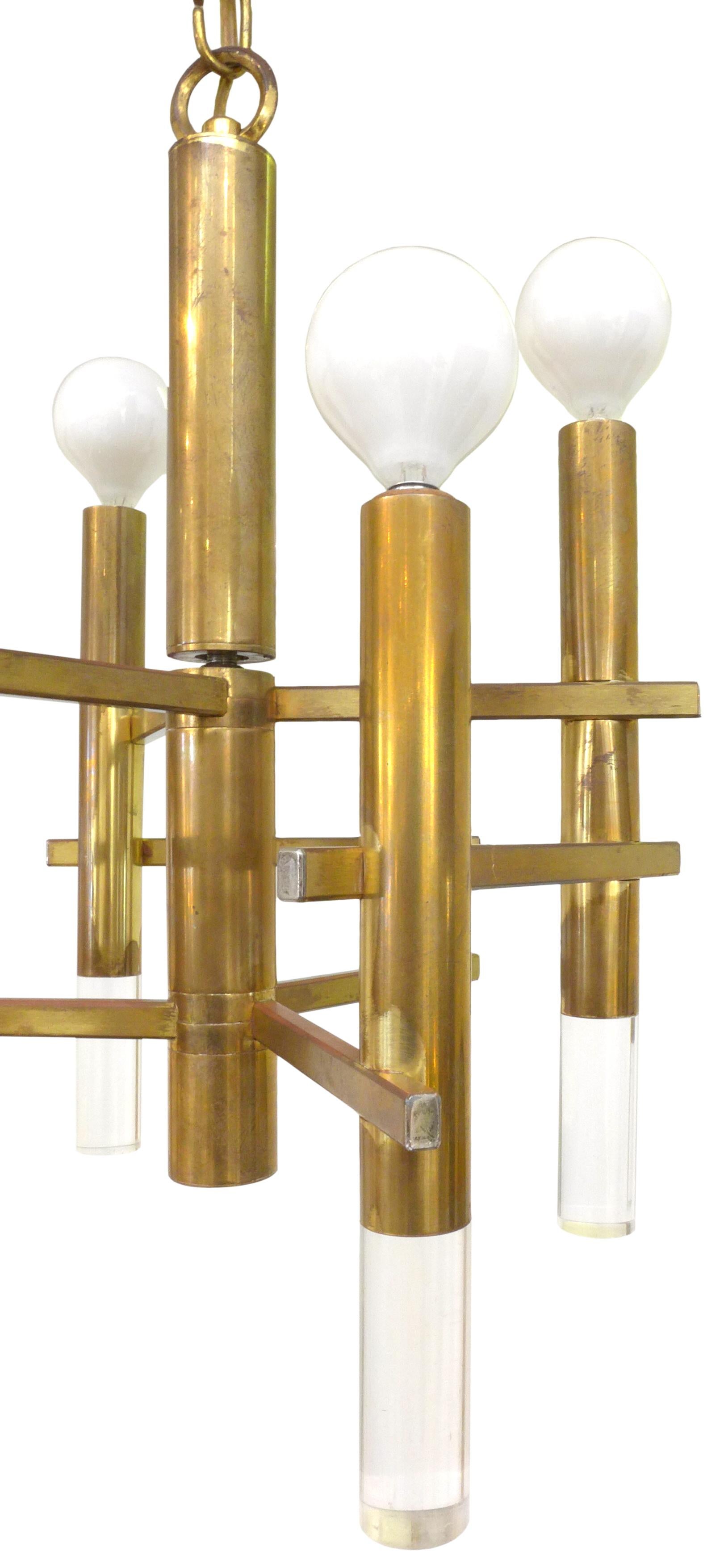 Modernist brass and Lucite chandelier, designed by Gaetano Sciolari. An interesting composition of cylindrical brass tubes with downward-oriented Lucite finials, fortified with horizontally applied square-stock brass “sticks”. Six up-light