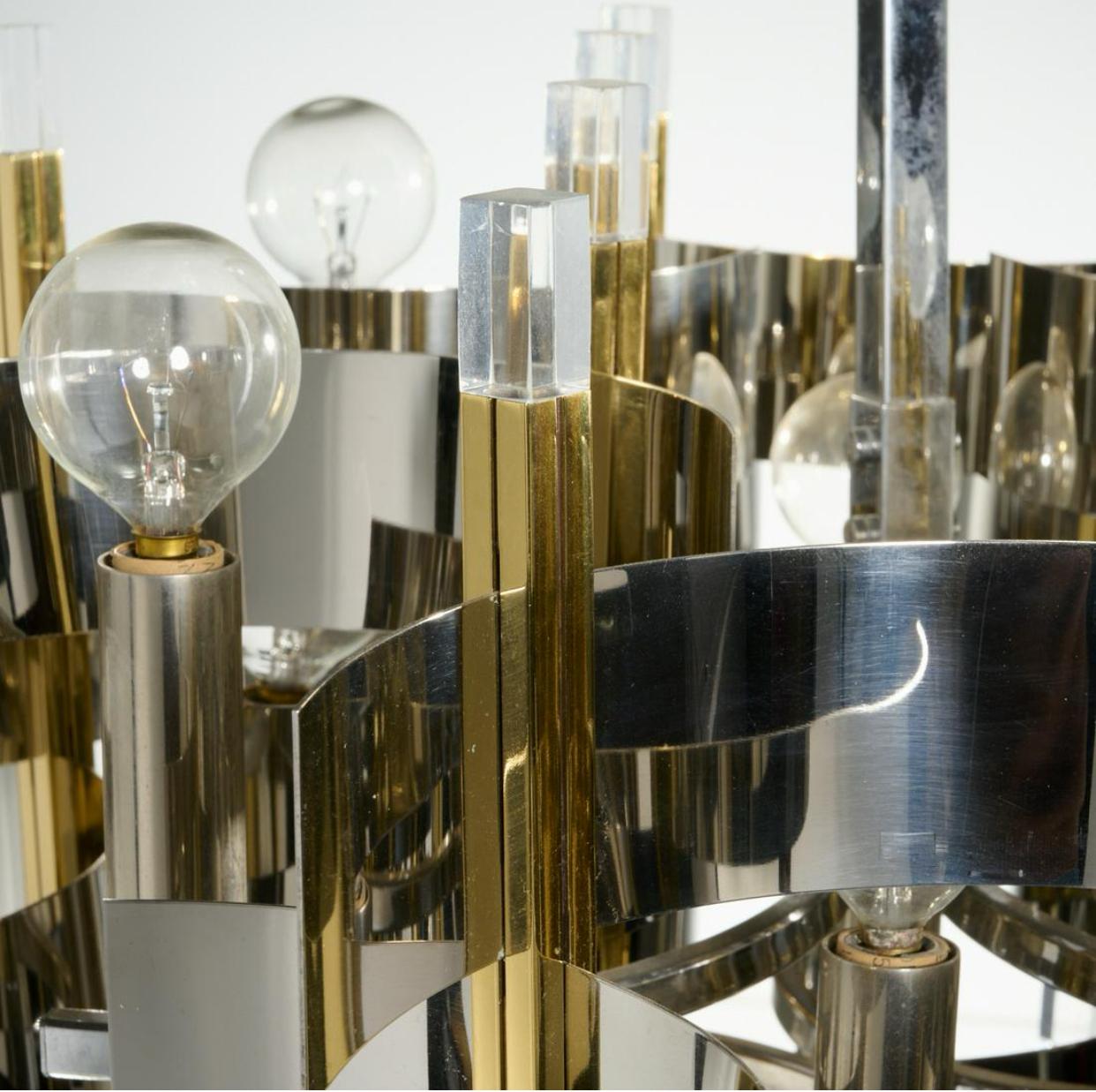 Ausgezeichneter Kronleuchter aus Messing, Chrom und Lucit, ca. 1960er Jahre, Italien. Außerdem gibt es quadratische Messingrohre mit Lucite-Enden, gebogene verchromte Bleche, gebürstete Metallrohre mit elektrifizierten Kandelaberfassungen an beiden
