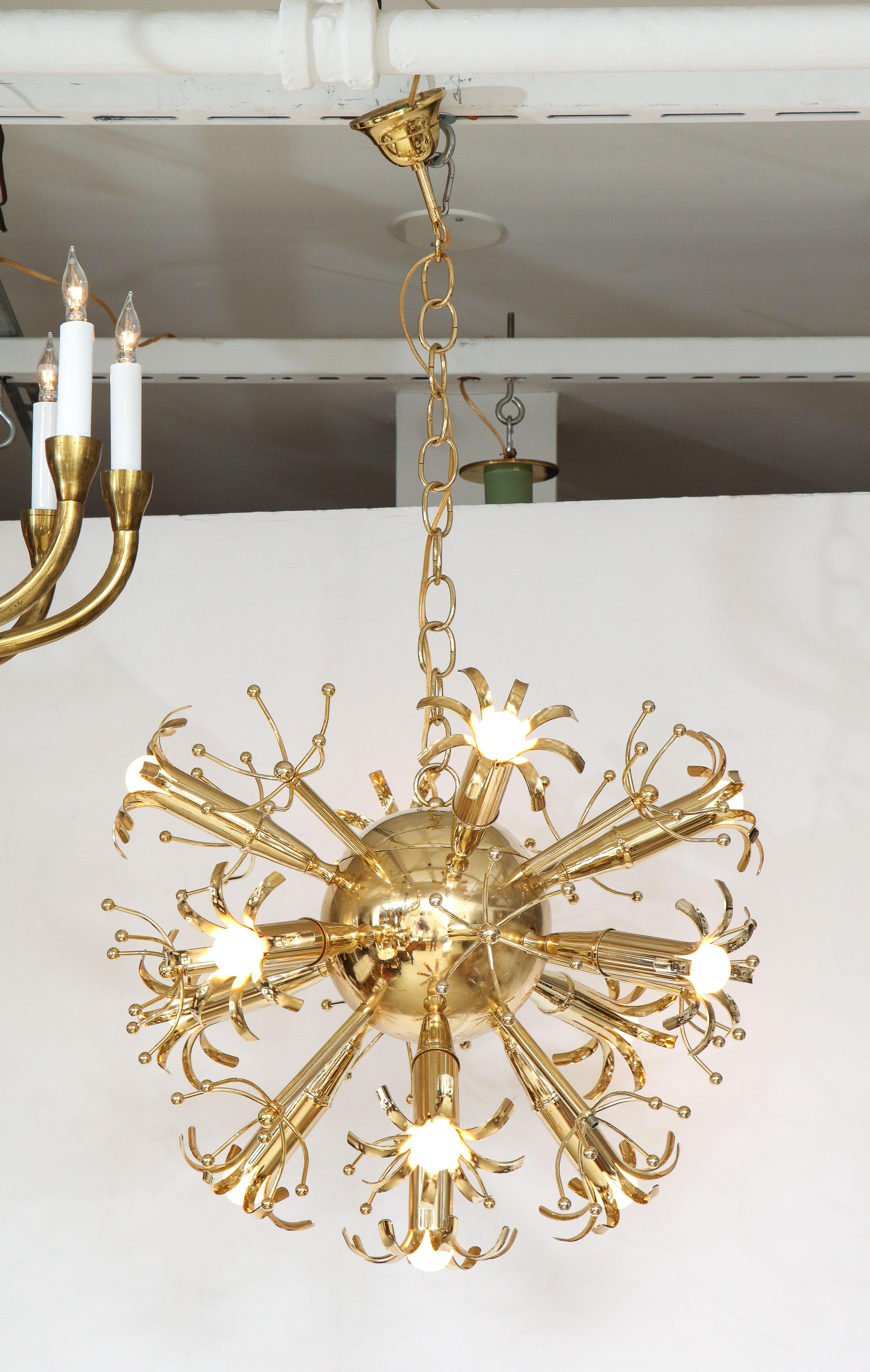 A very uniquely designed brass starburst Sputnik chandelier by Gaetano Sciolari. The dramatic arms emanate from the central brass ball, with its original brass canopy and chain. Newly rewired for USA standards. Height can be adjusted to any desired
