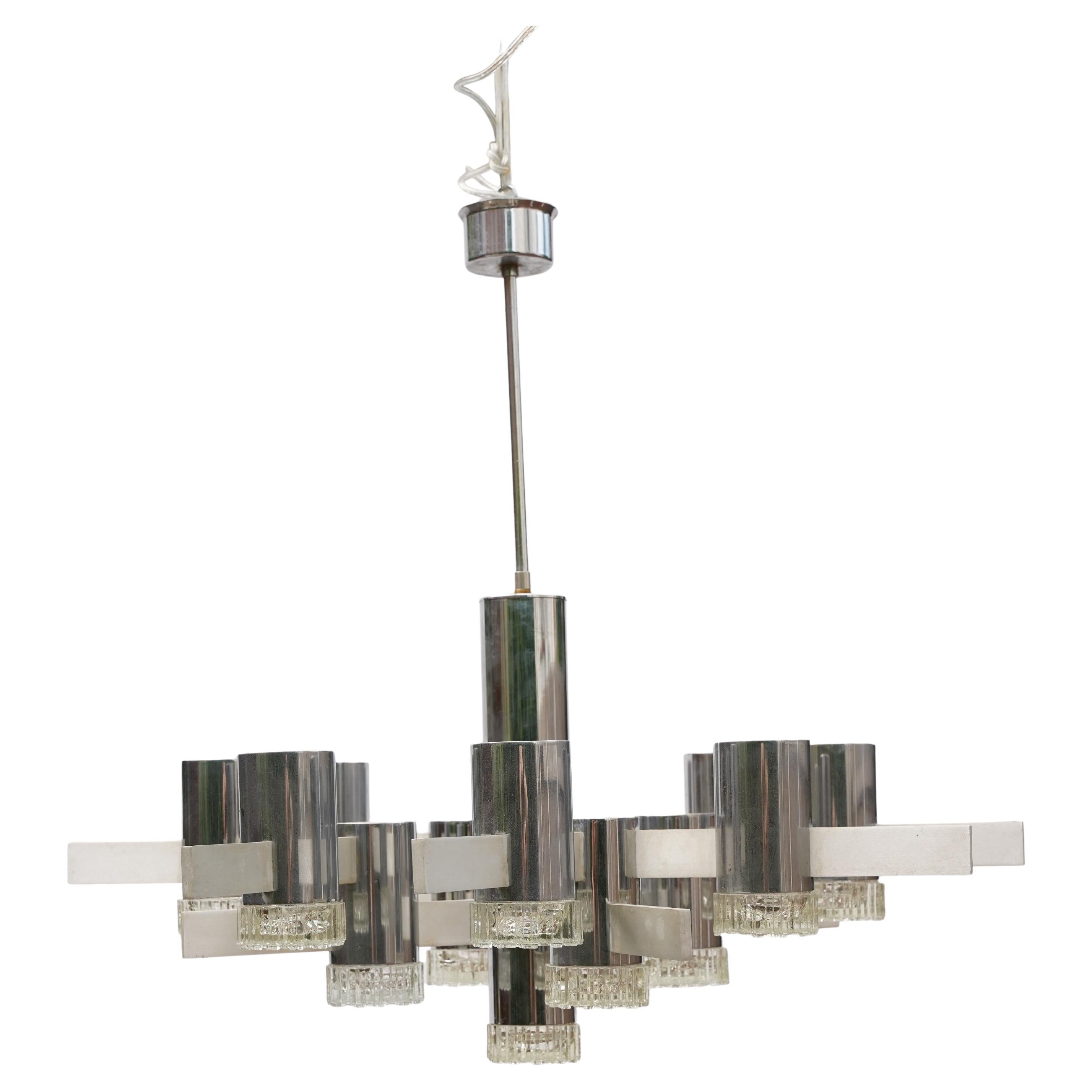 Gaetano Sciolari aluminum chandelier with glass diffusers, 1960 Italy .
brutalist aluminun frame holding 13 light points with glass diffusers set in a polished chrome frame .
13 glass diffusers , the frame has aged with patina, each crystal is 9