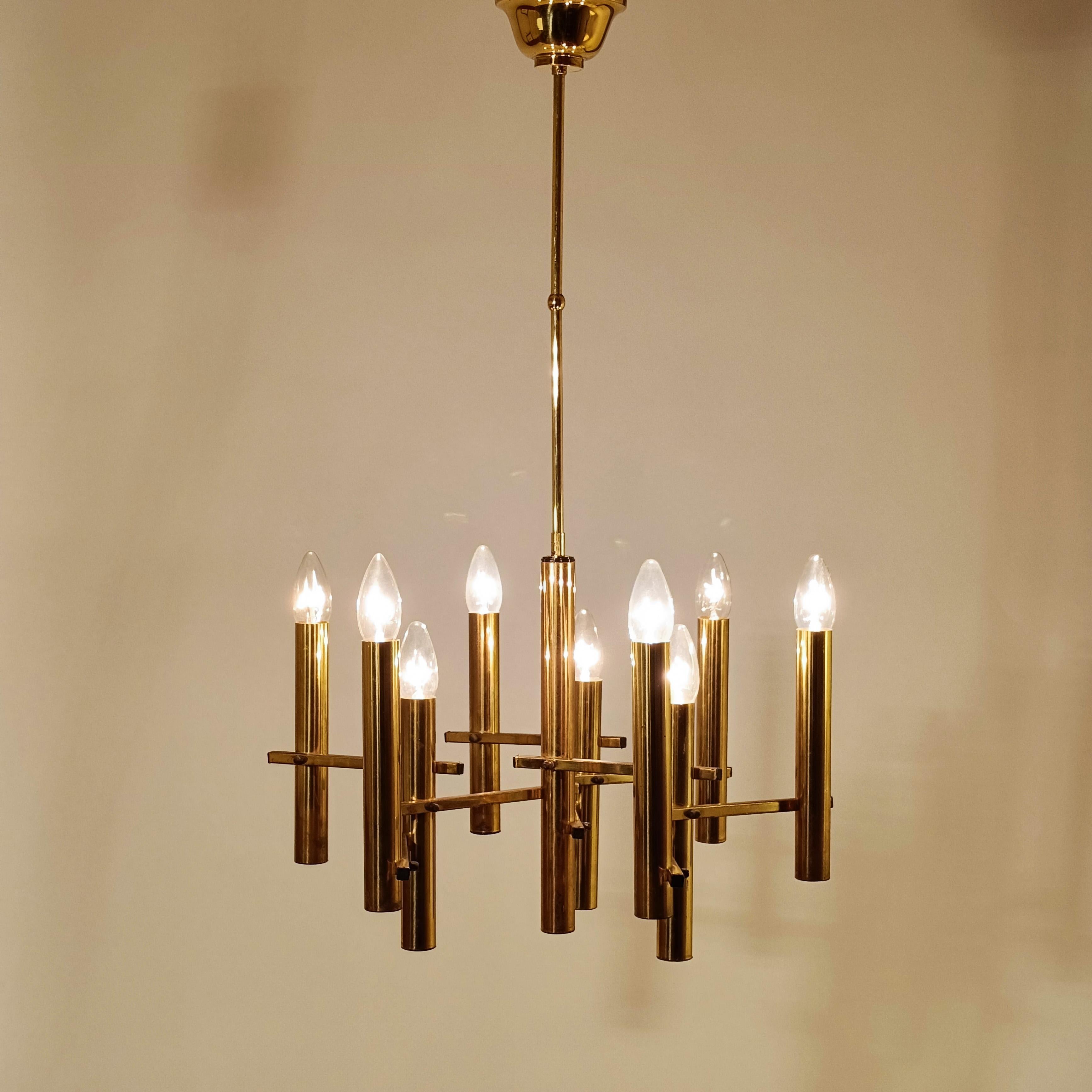 Lustre italien doré de Gaetano Sciolari, années 1970. Formé d'une structure tubulaire en laiton poli dans laquelle sont fixés 9 cylindres du même métal avec leurs 9 porte-lampes respectifs. Pièce très intemporelle de style brutaliste et Hollywood