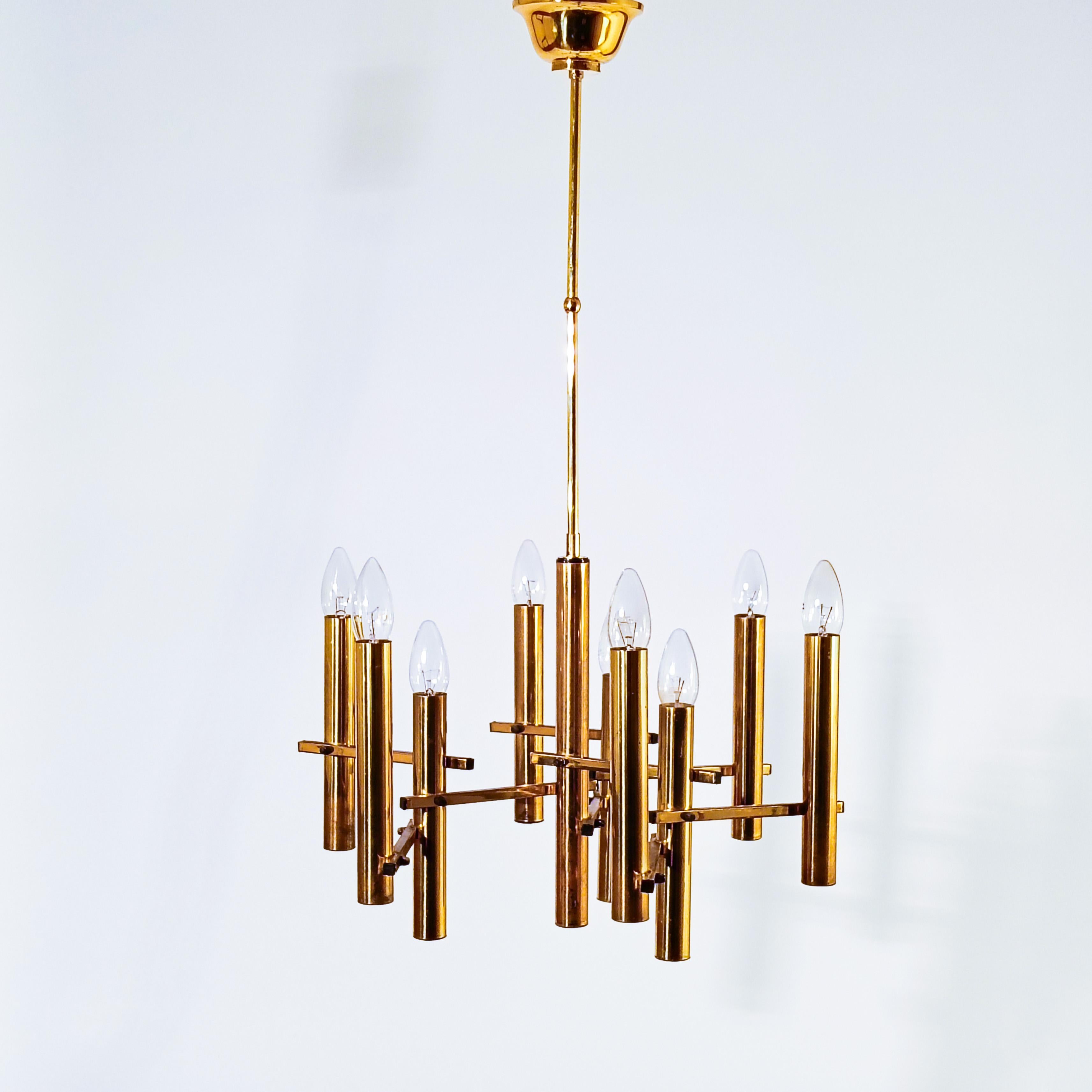 Italian gilded chandelier by Gaetano Sciolari, 1970s. Formed by a tubular polished brass structure in which 9 cylinders of golden chromed steel are attached with their respective 9 lamp holders. Very timeless piece in brutalist and Hollywood Regency