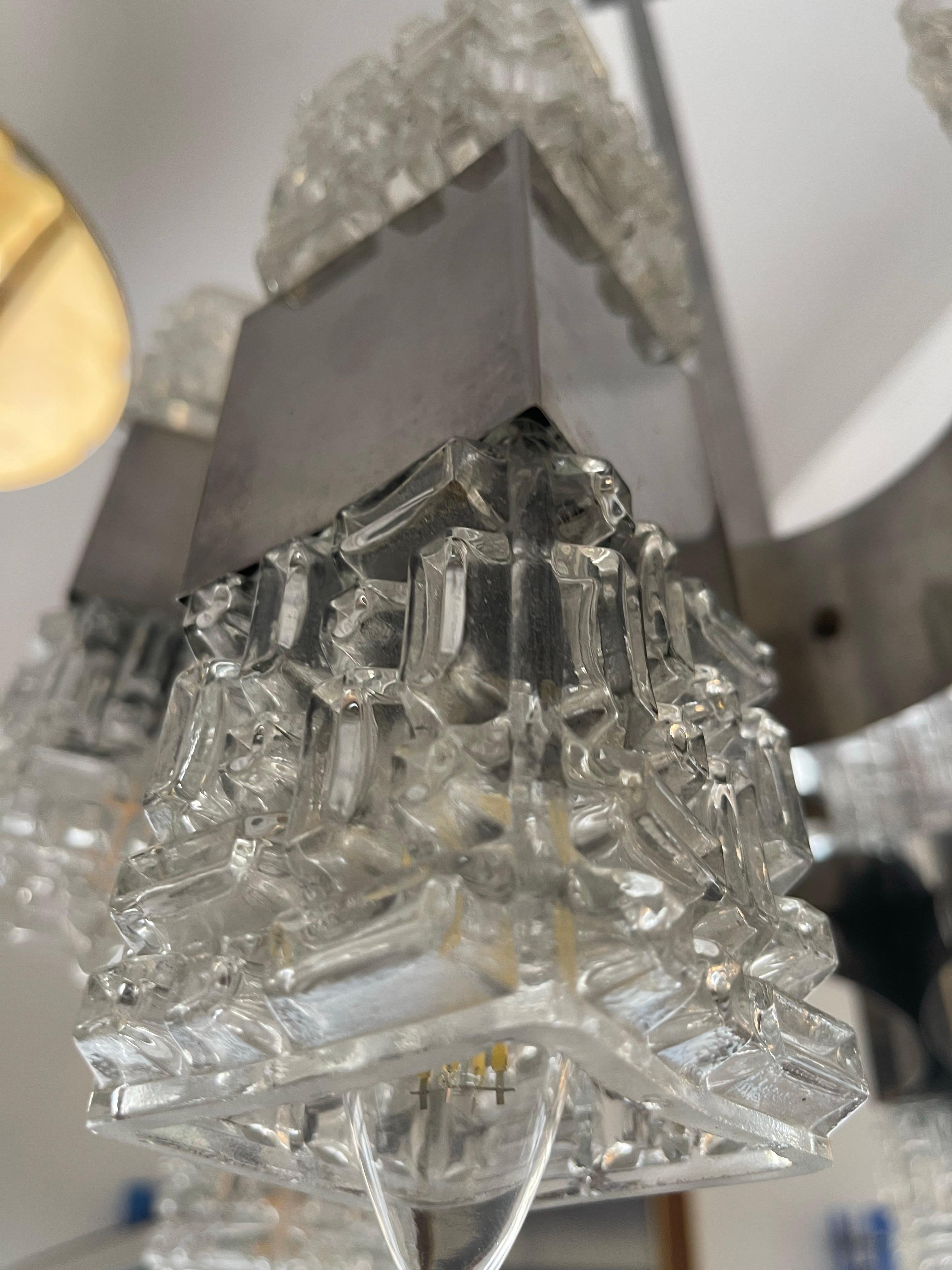 Italian glass and chrome chandelier from the 1960s, composed of 16 square brutalist cubist glasses: 8 facing upwards and 8 facing downwards. Designed by Gaetano Sciolari for Sciolari Lighting. The glasses rest on a polished chrome steel structure,