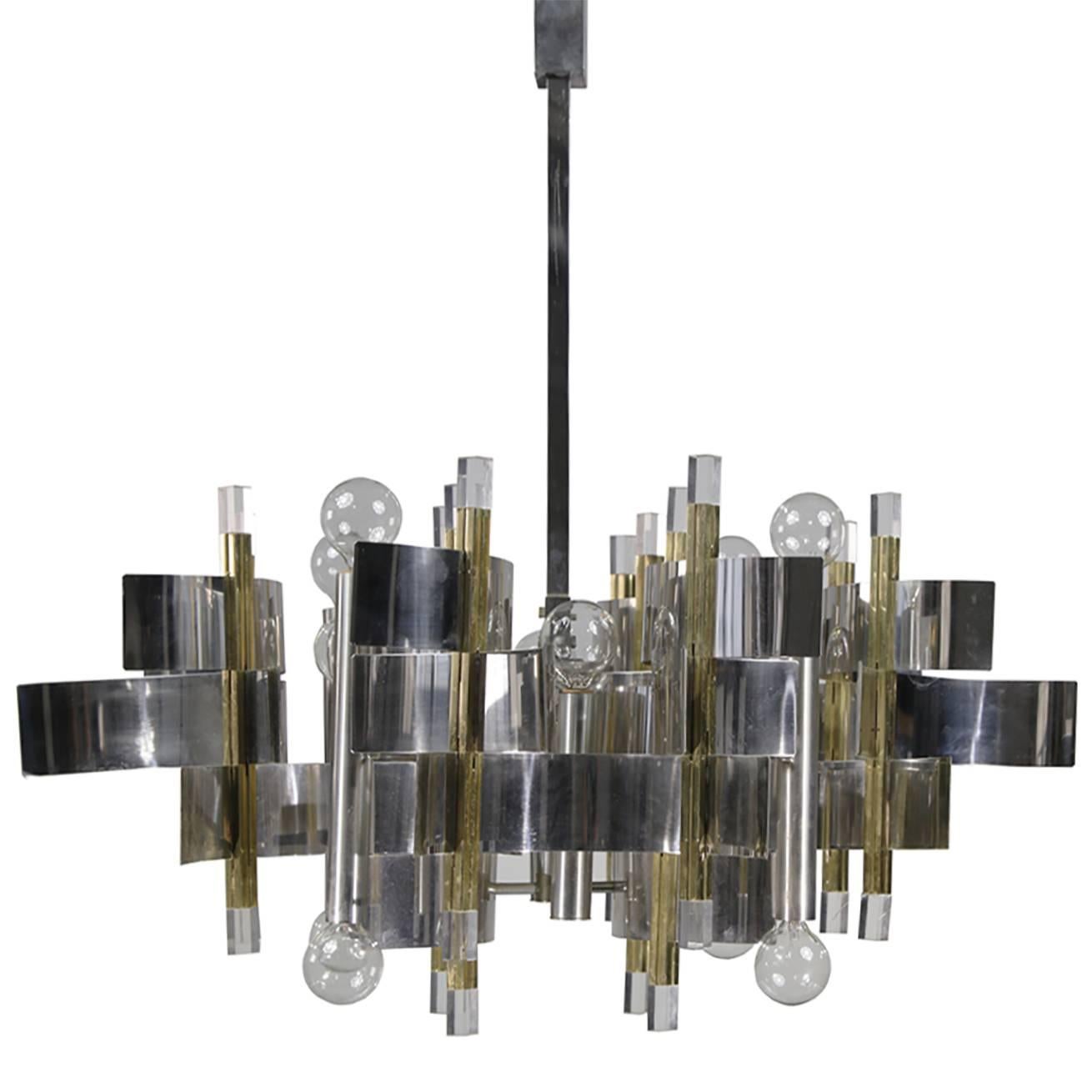 Twelve-light two-tone expressionist chandelier by Gaetano Sciolari.
Chrome finished bent metal arcs in polished and satin finish, combine and tier between brass poles accented by acrylic tips in a structured and highly stylized cubic integration.