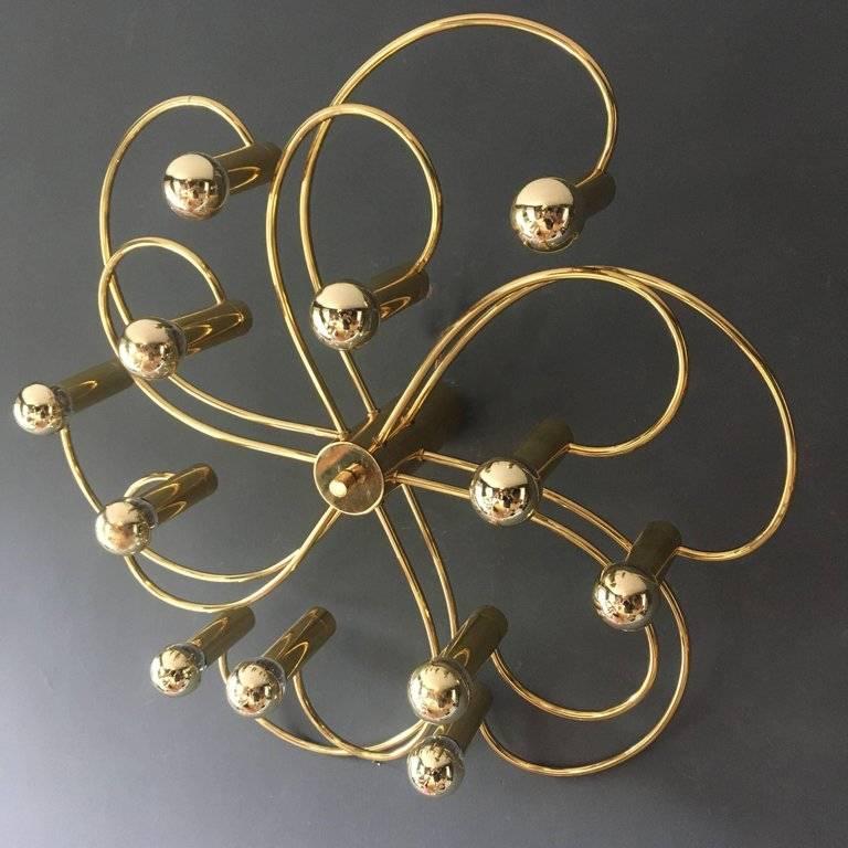 Brass ceiling light by Gaetano Sciolari for Silkronen, Germany

The light is arranged in two layers of curled arms from the centre post holding six bulbs each, the light has 12 bulbs totally.

The centre post fits flush to the ceiling with a