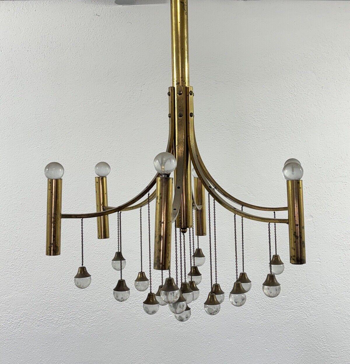 Gaetano Sciolari Brass Chandelier Mid-Century Design Modernism.

All-brass frame, crystal drops.

6 light points.

The item is in good conservative condition, no major cosmetic or structural defects to report, slight and obvious signs of time due to