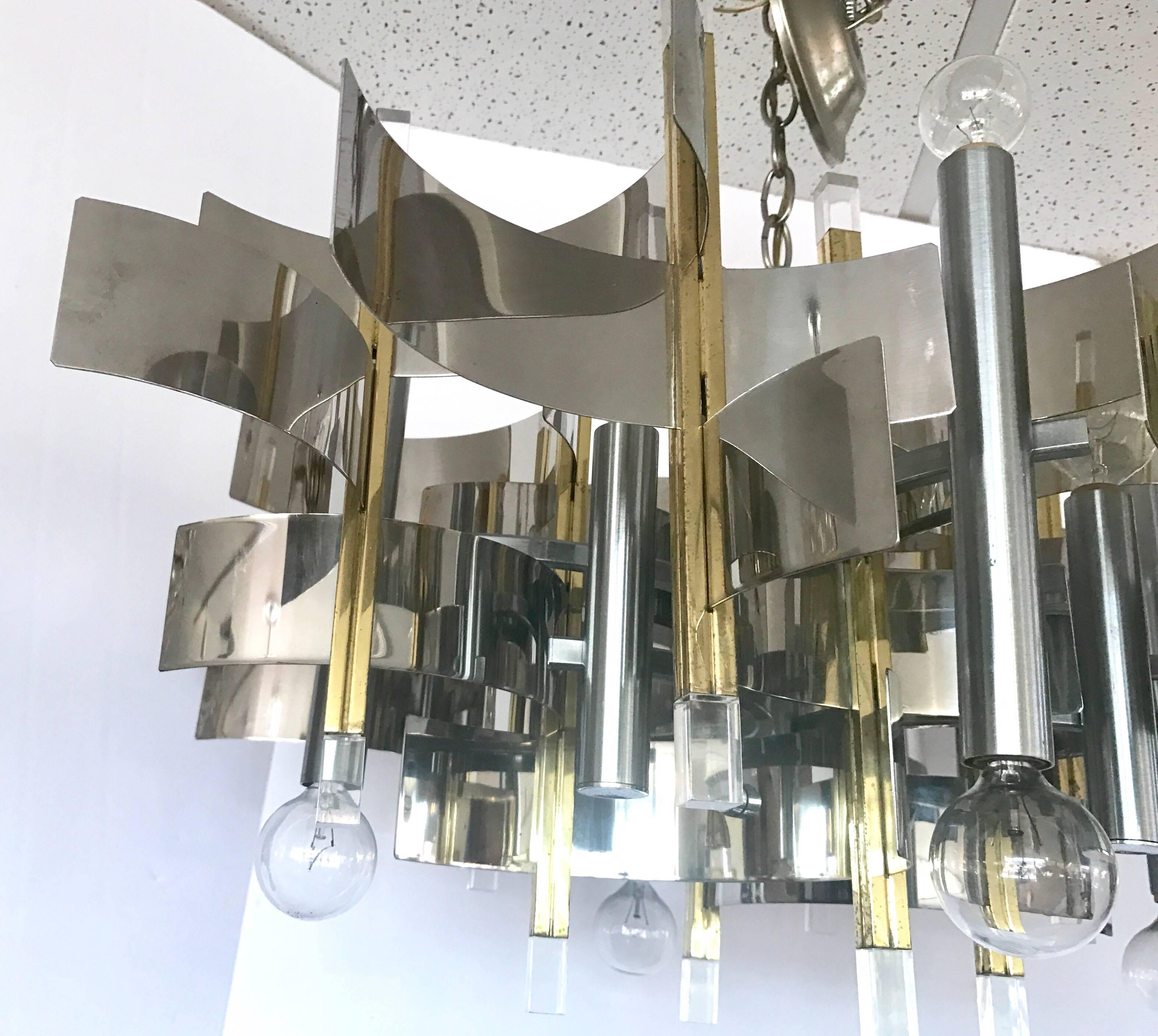 Magnificent Sciolari 1970s chandelier. Classic lines in Lucite metal and brass. Made in Italy.
Features nine lights and a scale that works in several layouts. Why not own the best?
Wired for USA and in perfect working order. The chain is