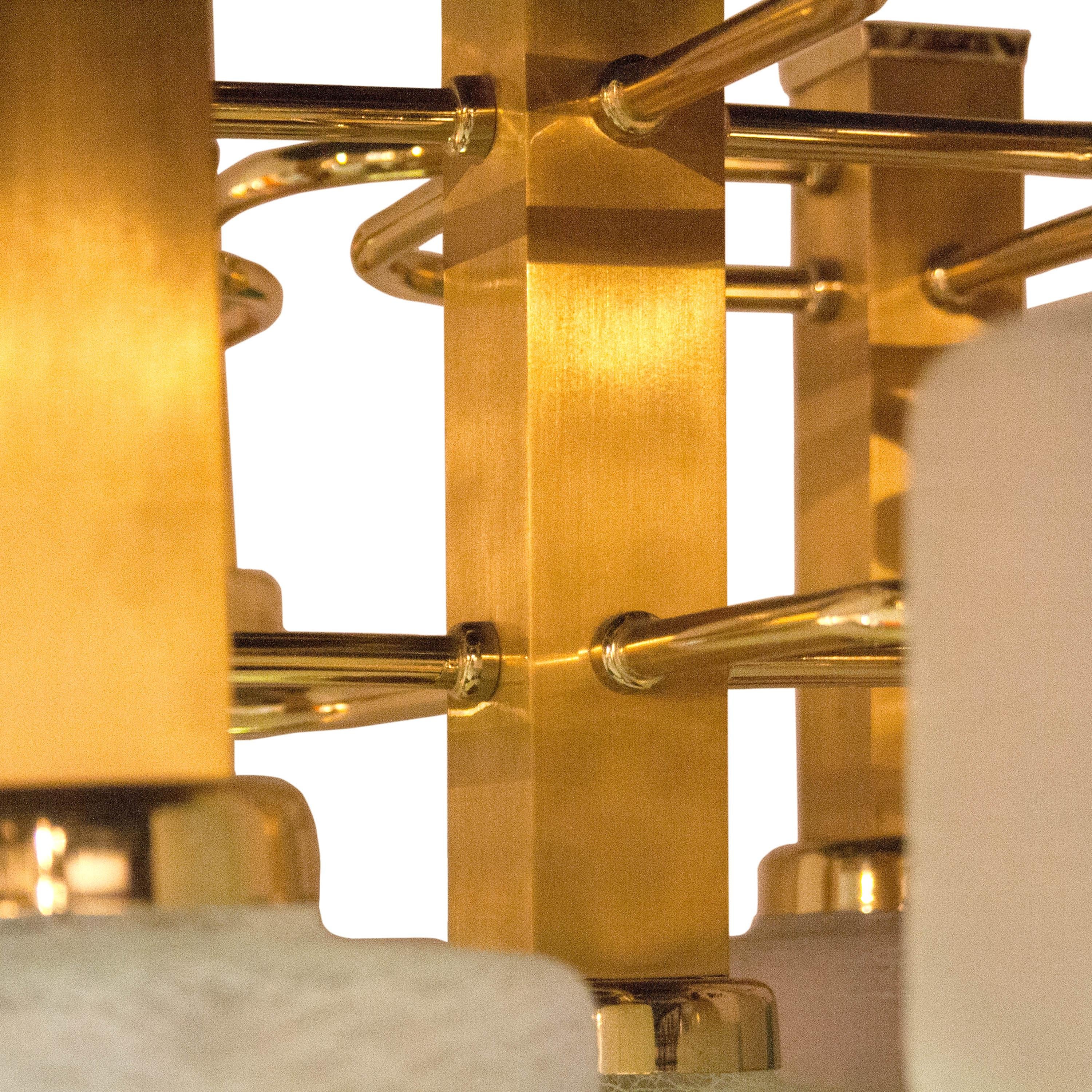 Ceiling lamp with geometric brass structure and nine points of light in polyhedral glass cups designed by Gaetano Sciolari.