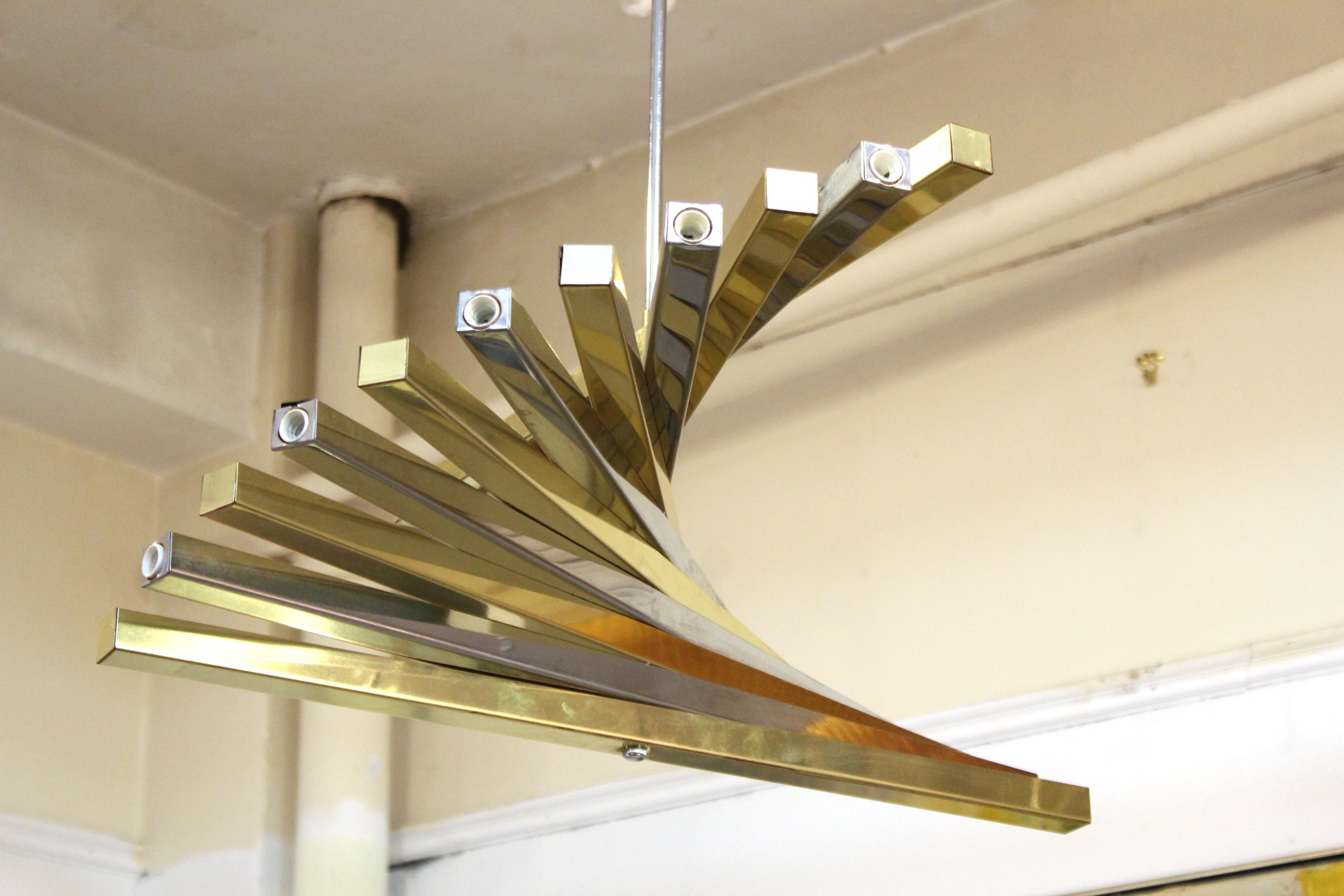 Modern Italian spiraling chandelier pendant designed by Gaetano Sciolari. The piece has alternating brass and chrome elements cascading down in a spiraling movement. In great vintage condition with age-appropriate wear.