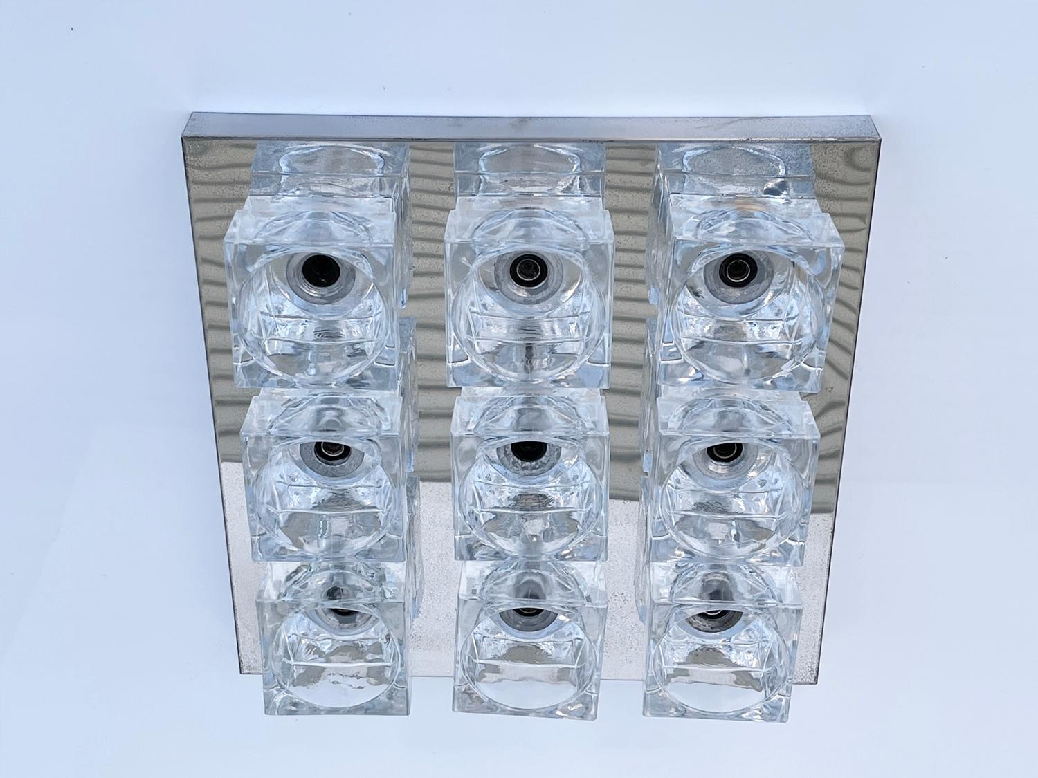Noted Italian lighting designer Gaetano Sciolari designed the futuristic Cubic series in the 1970s. Distributed in the USA by Lightolier.
These designs have stood the test of time. This example features nine large scale heavy glass cubes fixed to a