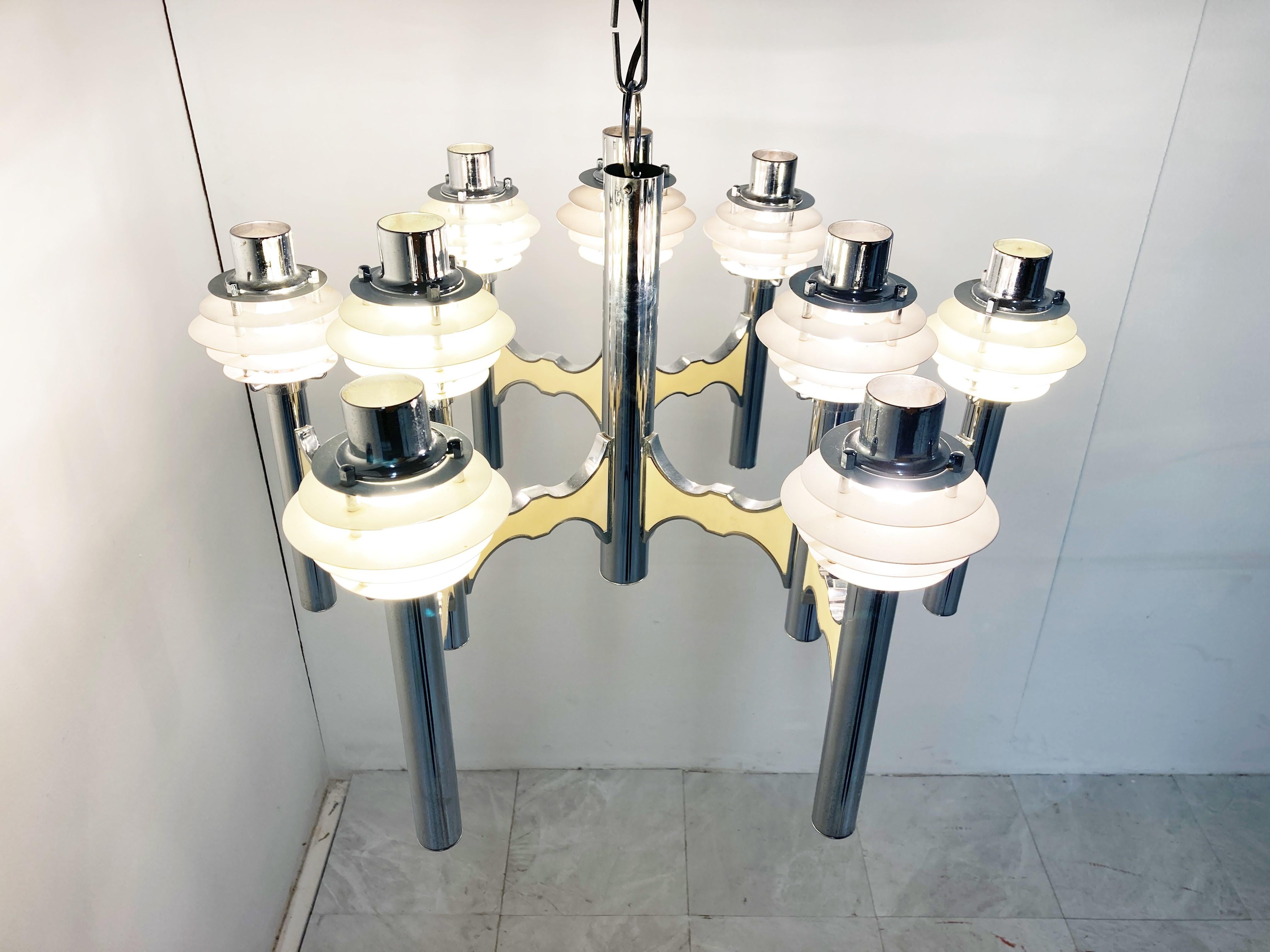 Chrome space age 'saturn' design chandelier with beige lacquer arms and enamelled saturn like lamp shades.

Designed by Gaetano Sciolari.

9 Lightpoints working with regular E14 light bulbs

Good condition

1970s -