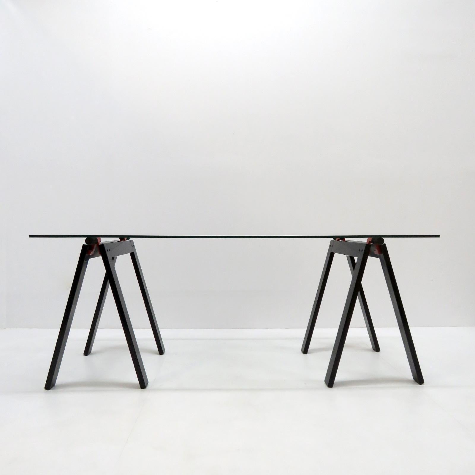 Gaetano working table by Gae Aulenti for Zanotta with original glass top, supported by two black and red enameled metal folding working horses alike base. Documented: see Repertorio Italian design book at page # 385.