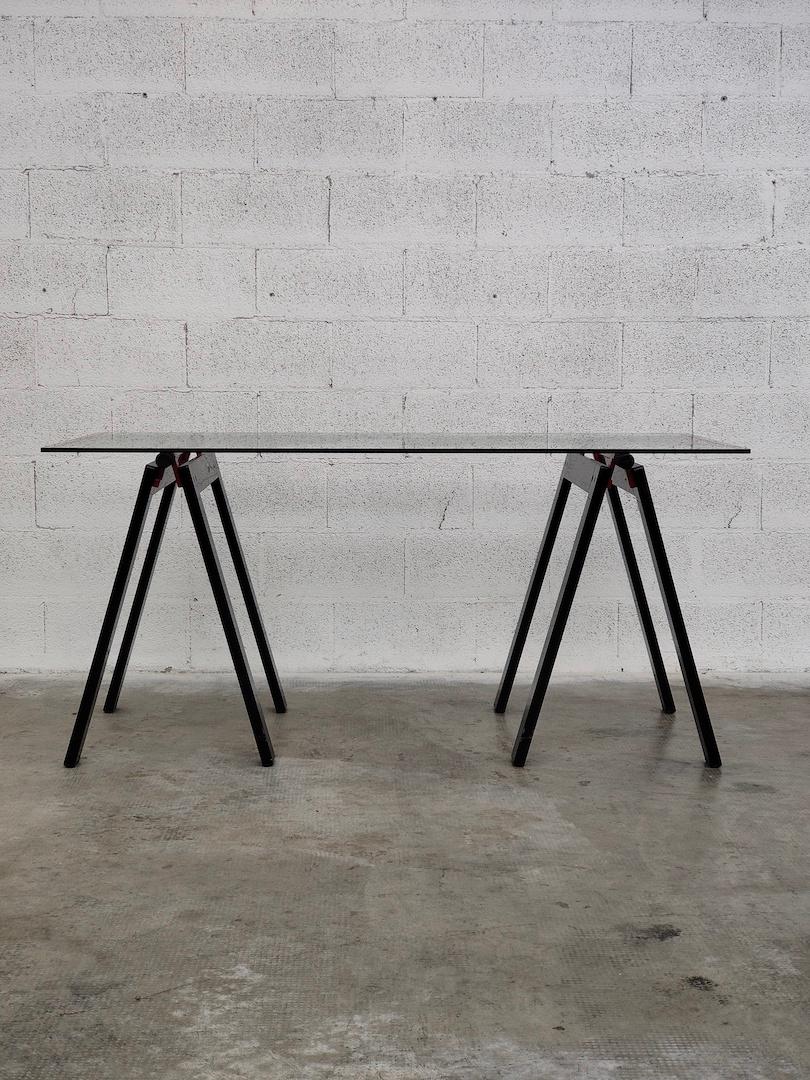 Gaetano work table by Gae Aulenti for Zanotta with original glass top supported by two folding trestles in black and red enamelled metal.
Timeless object. With a dry and essential design, it combines modernity and elegance. It can be placed in many