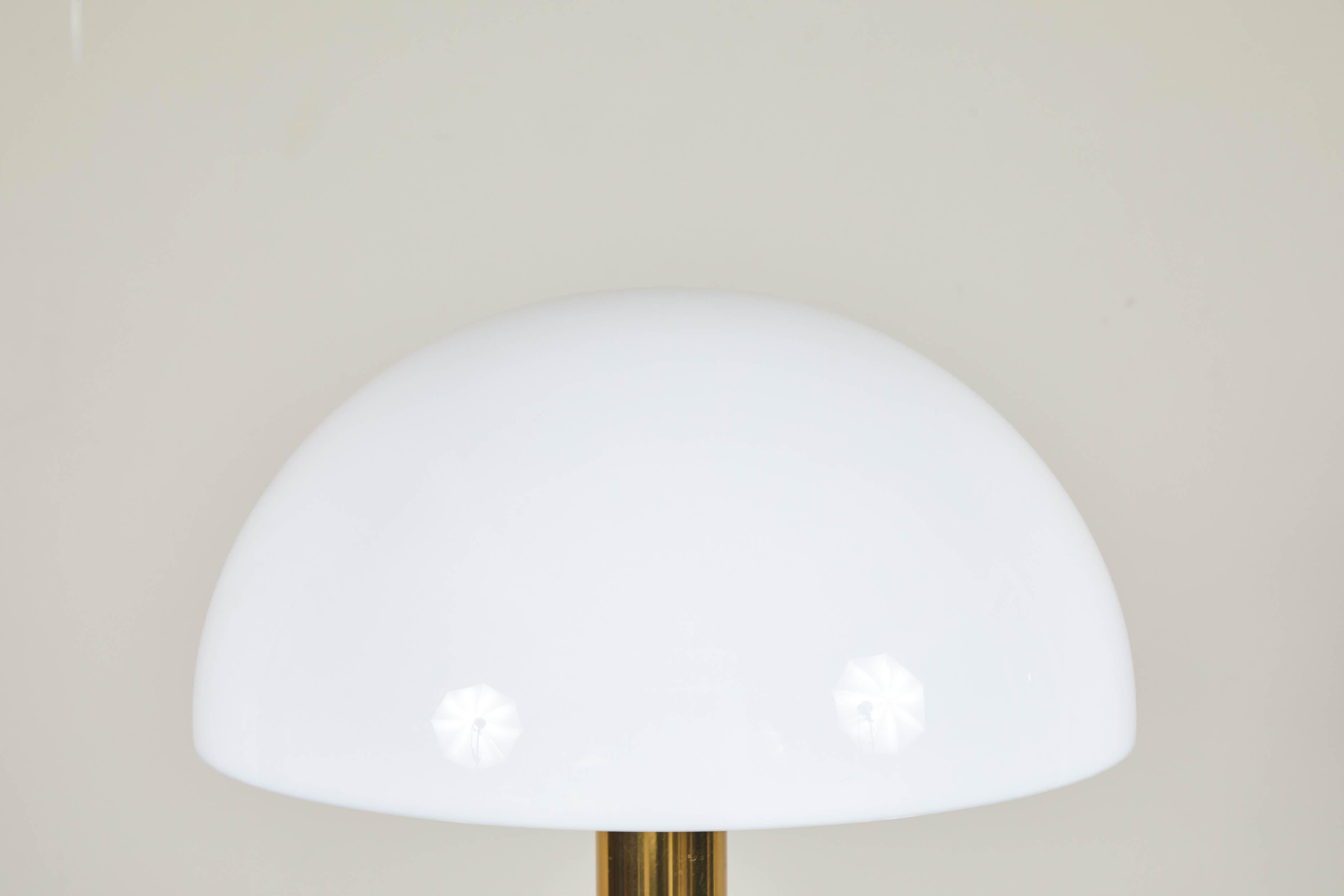A Gage Cauchois brass and Lucite table lamp. The three-way dimmer is touch-controlled on the brass stem. Lucite base and exposed bulb with a frosted Lucite dome.