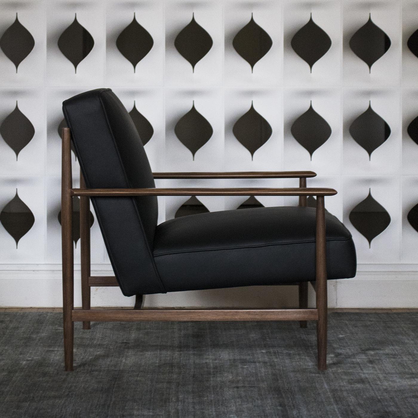 The Gaia Black Leather Armchair is elegant, refined and comfortable, with a unique interlocking structure made from walnut by the finest Italian craftsmen.\nEach piece is unique thanks to the different tones and grain of the wood and the seat is