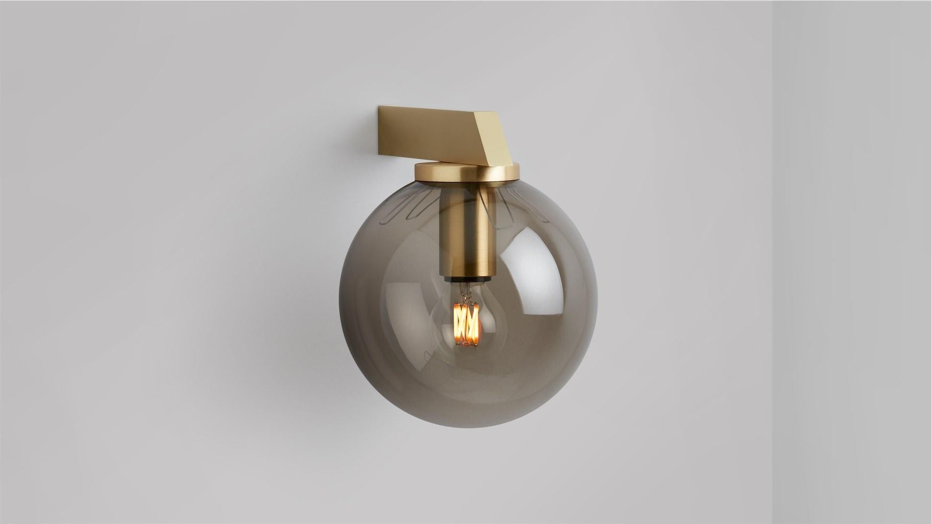 Gaia wall lamp by CTO Lighting
Materials: Satin brass with tinted glass.
Dimensions: D 21.4 x W 15 x H 19 cm
Available in bronze or satin brass and in hand shaped smoke glass, matte opal glass, shiny opal glass, or tinted glass.

An elegant linear